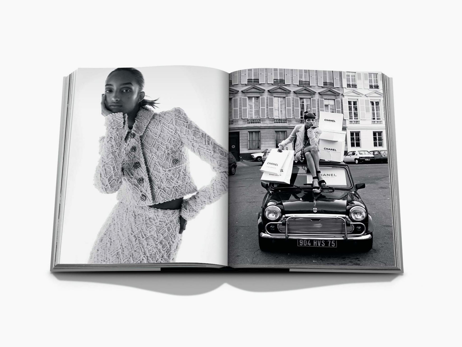 Monochrome Chanel editorial spread with a model in a textured coat on the left and a car with Chanel boxes on the right.