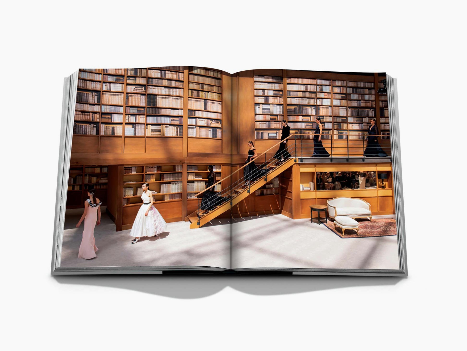 Luxurious library interior with tall shelves and a staircase as seen in a Chanel Mémoire edition.