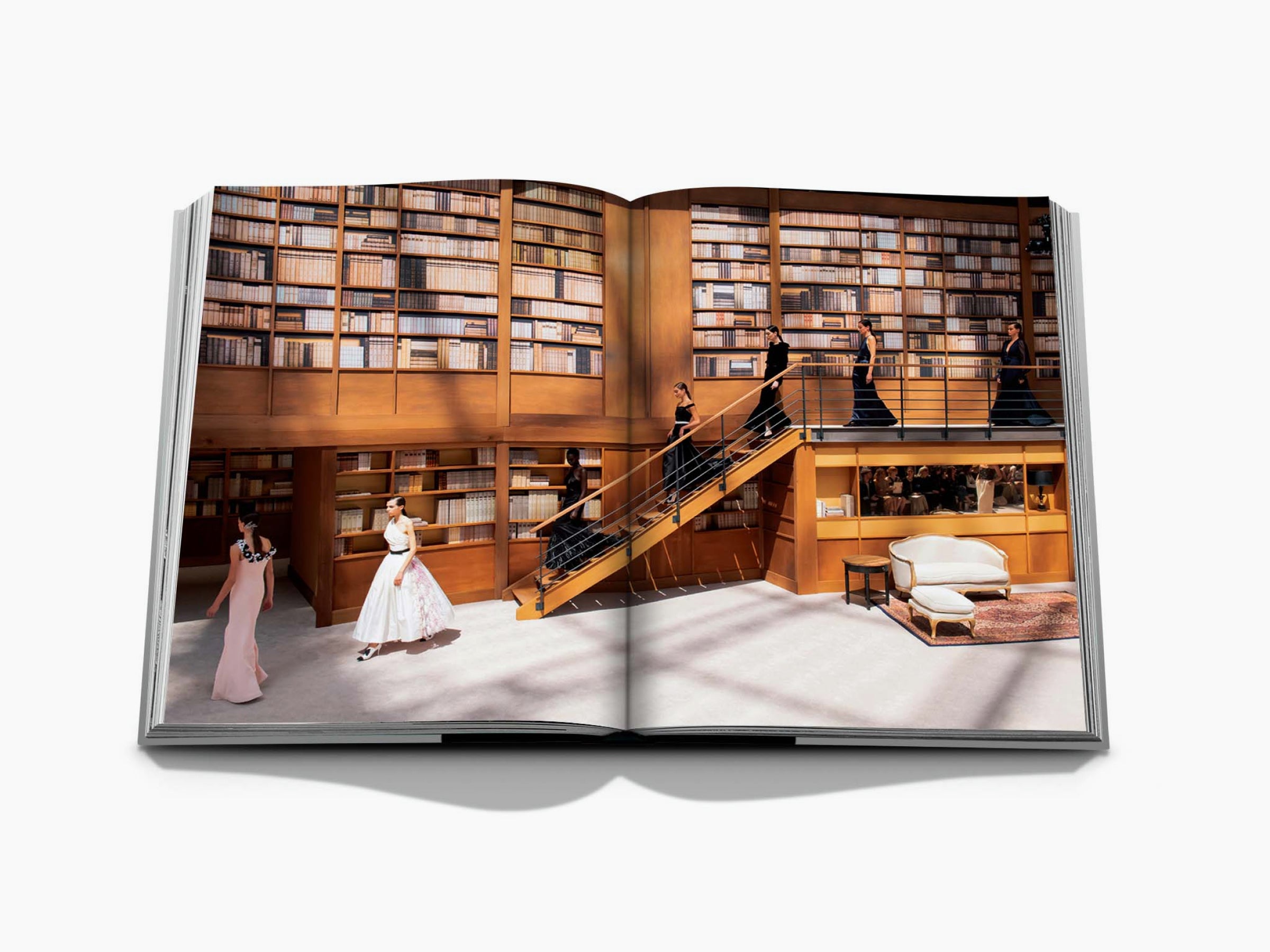 Luxurious library interior with tall shelves and a staircase as seen in a Chanel Mémoire edition.
