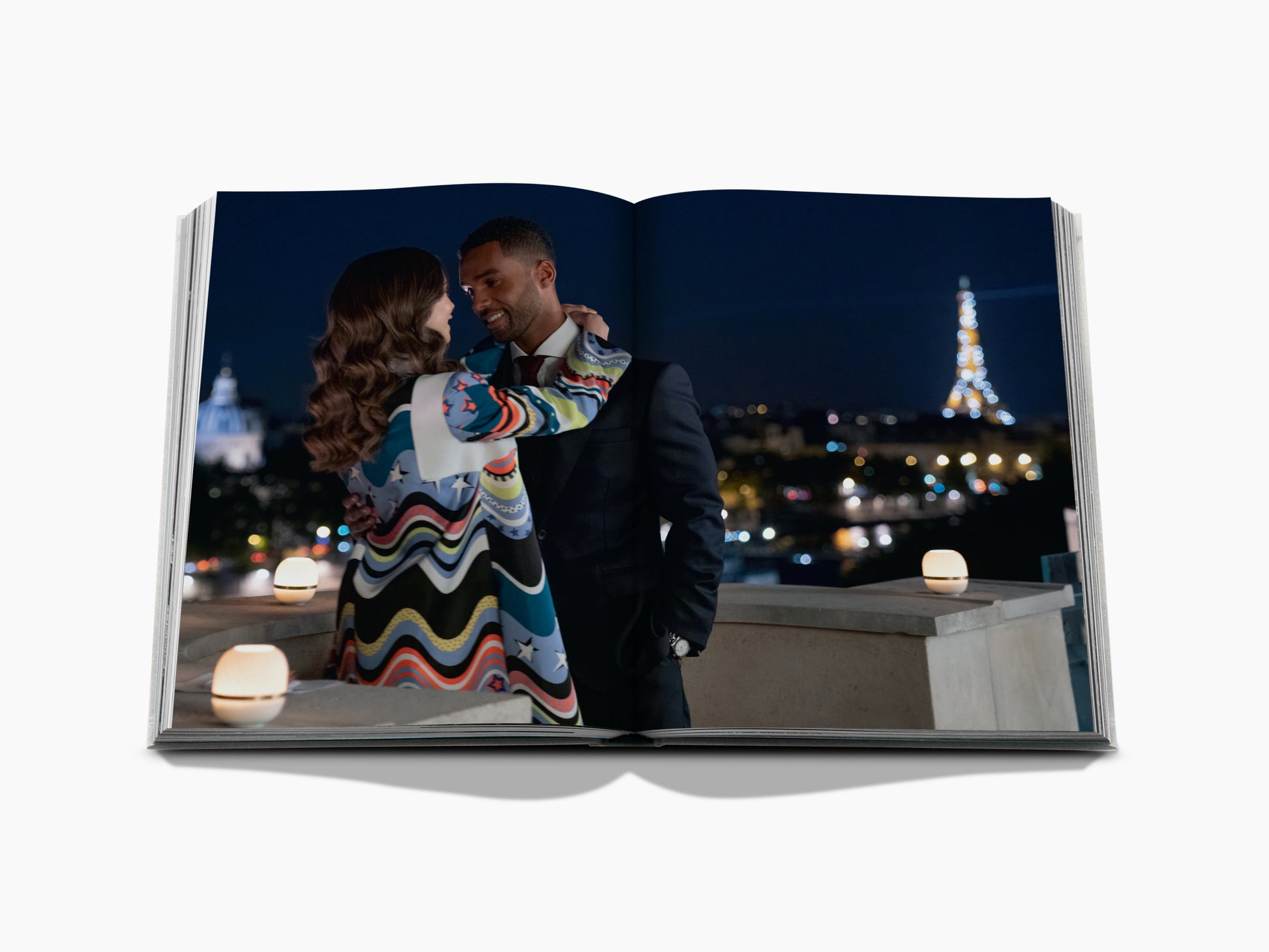 Nighttime rooftop scene of a couple in formal wear embracing with the Paris skyline and the lit Eiffel Tower.