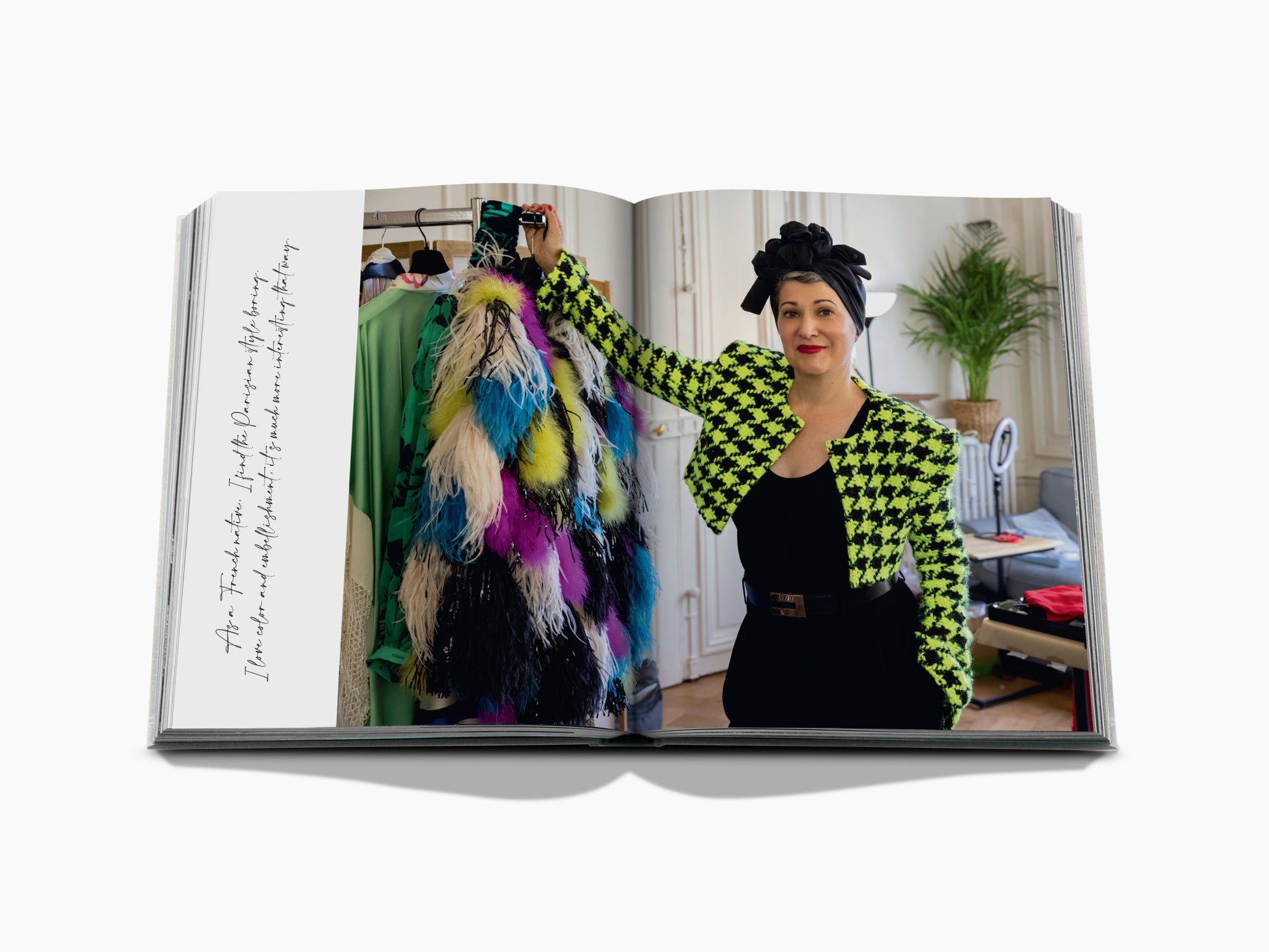 Portrait of a stylish woman in a neon lime green and black houndstooth blazer in a dressing room with colorful garments.