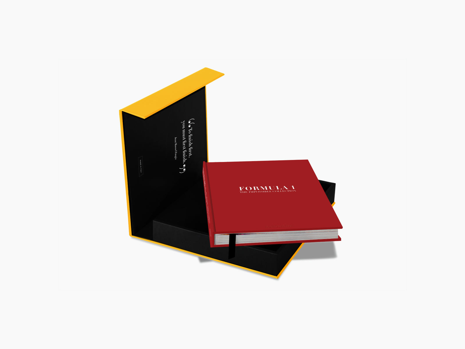 Open yellow and black gift box with a red Formula 1 book inside and a white glove draped over the lid