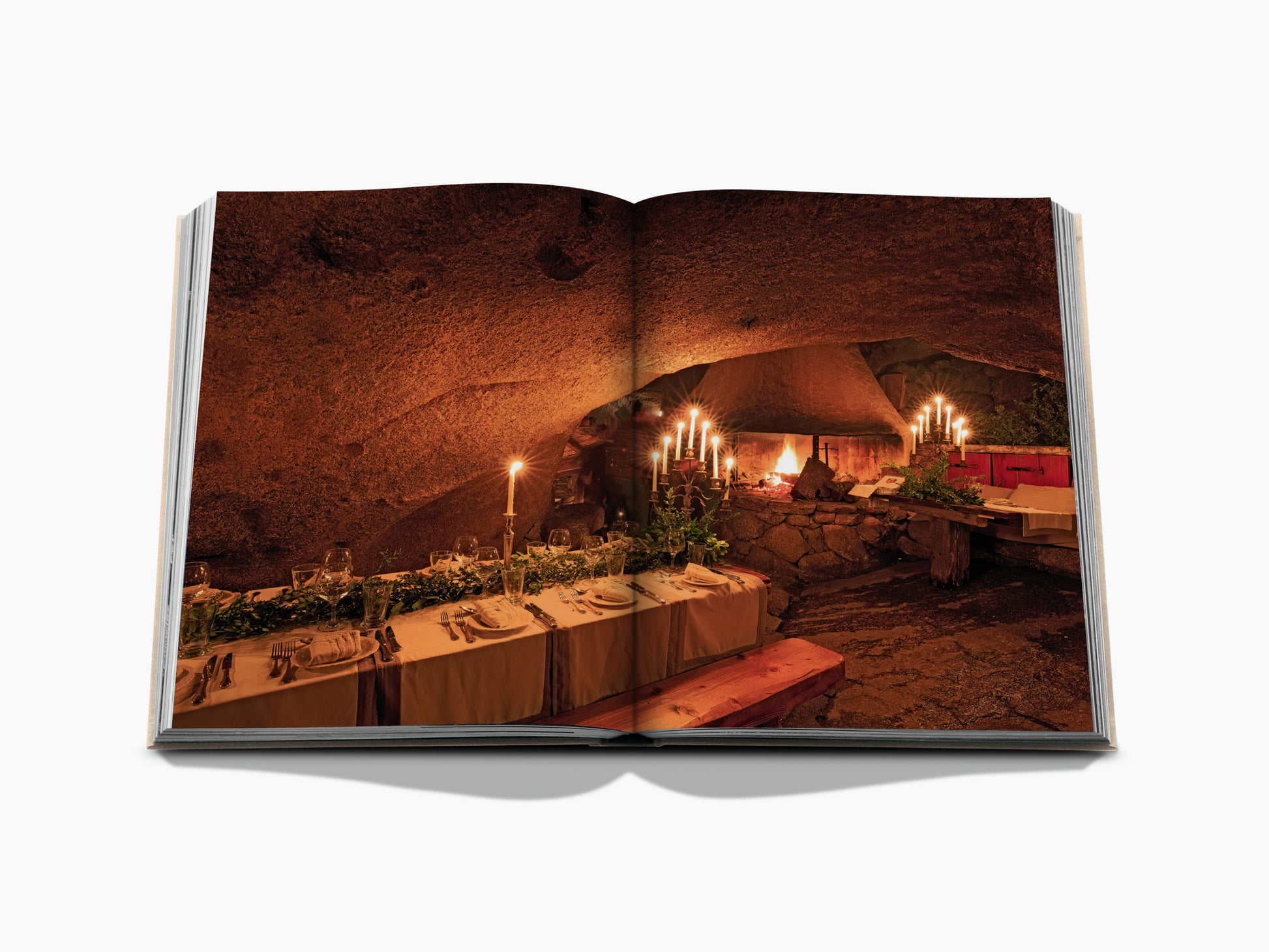 Candlelit cave dining setup shown in an open wine travel book spread