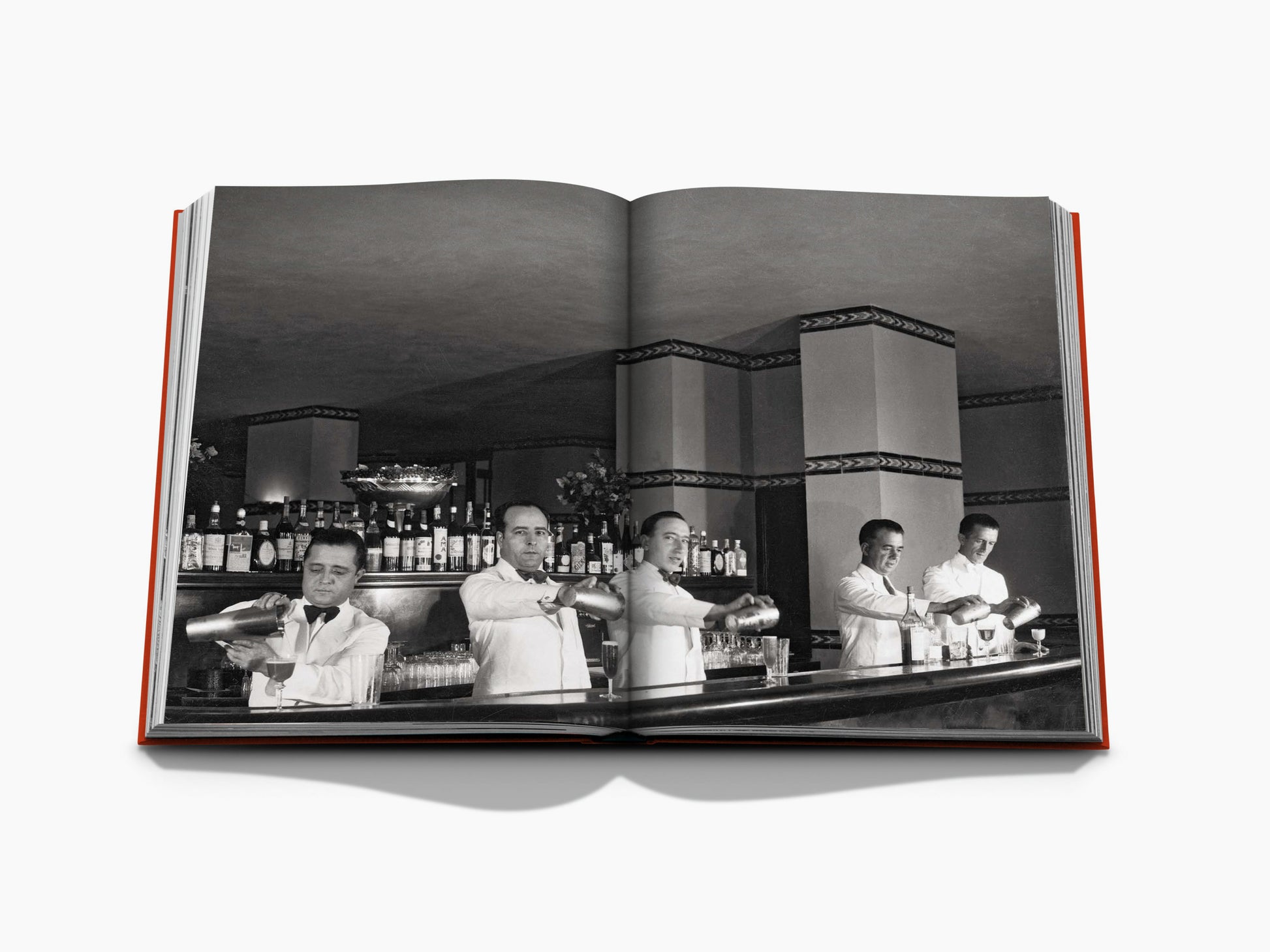 Open book spread shows a black and white Havana bar scene with five bartenders pouring drinks behind a long bottle lined counter