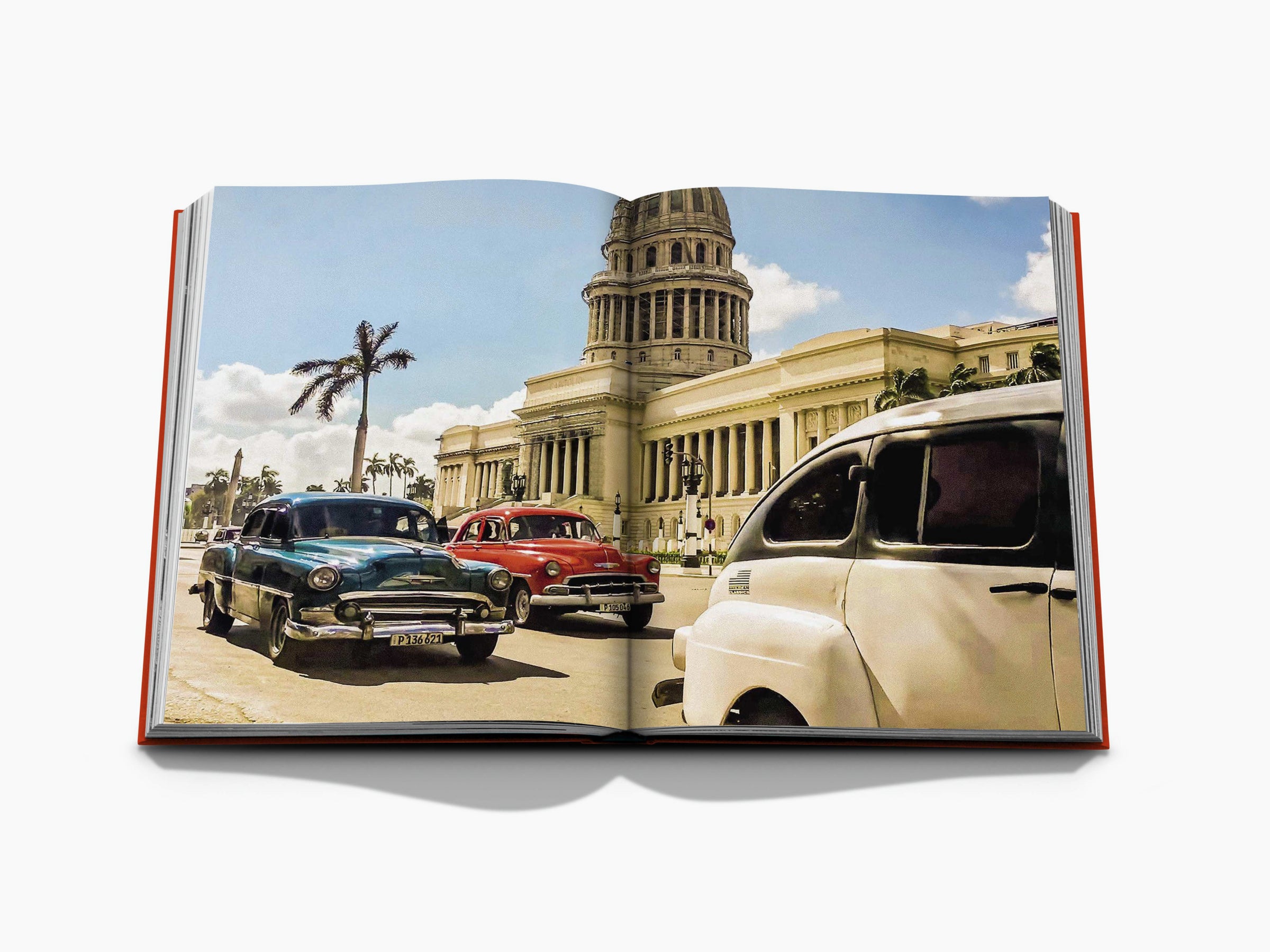 Open book spread of a Havana street scene with vintage cars parked near a grand building under a blue sky.