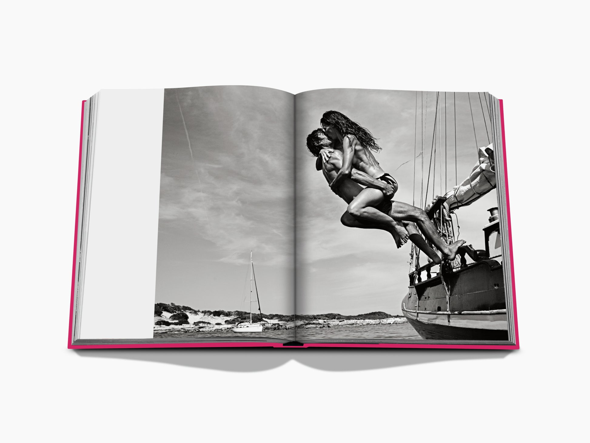 Open book spread with a black and white photo of a couple leaping from a boat into the sea against a rocky coastline.