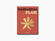 Marrakech Flair book cover with bold title and a yellow flower motif on a warm red-orange background