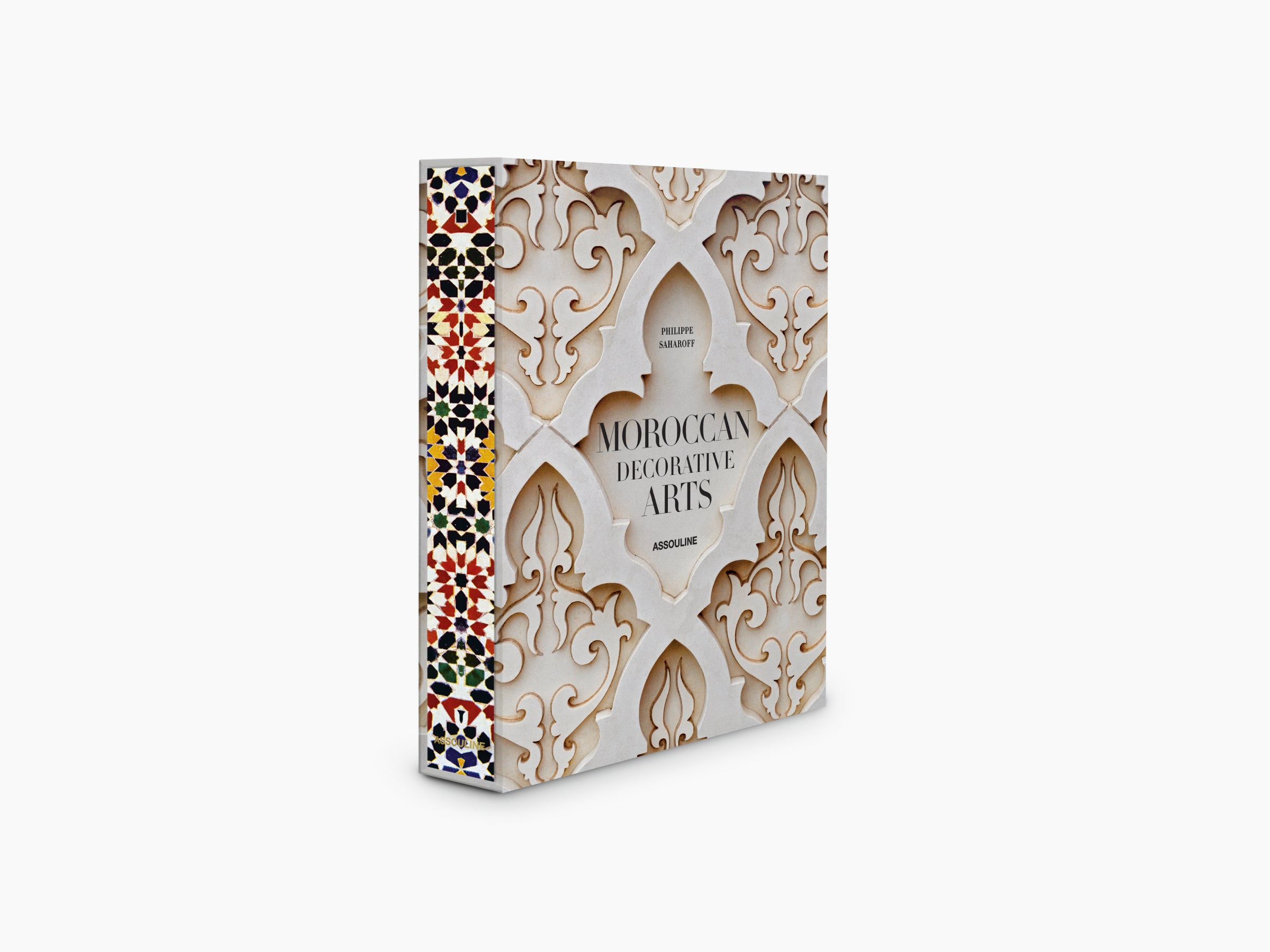 Moroccan Decorative Arts book angled to show cream plaster pattern and a vivid mosaic strip along the left edge.