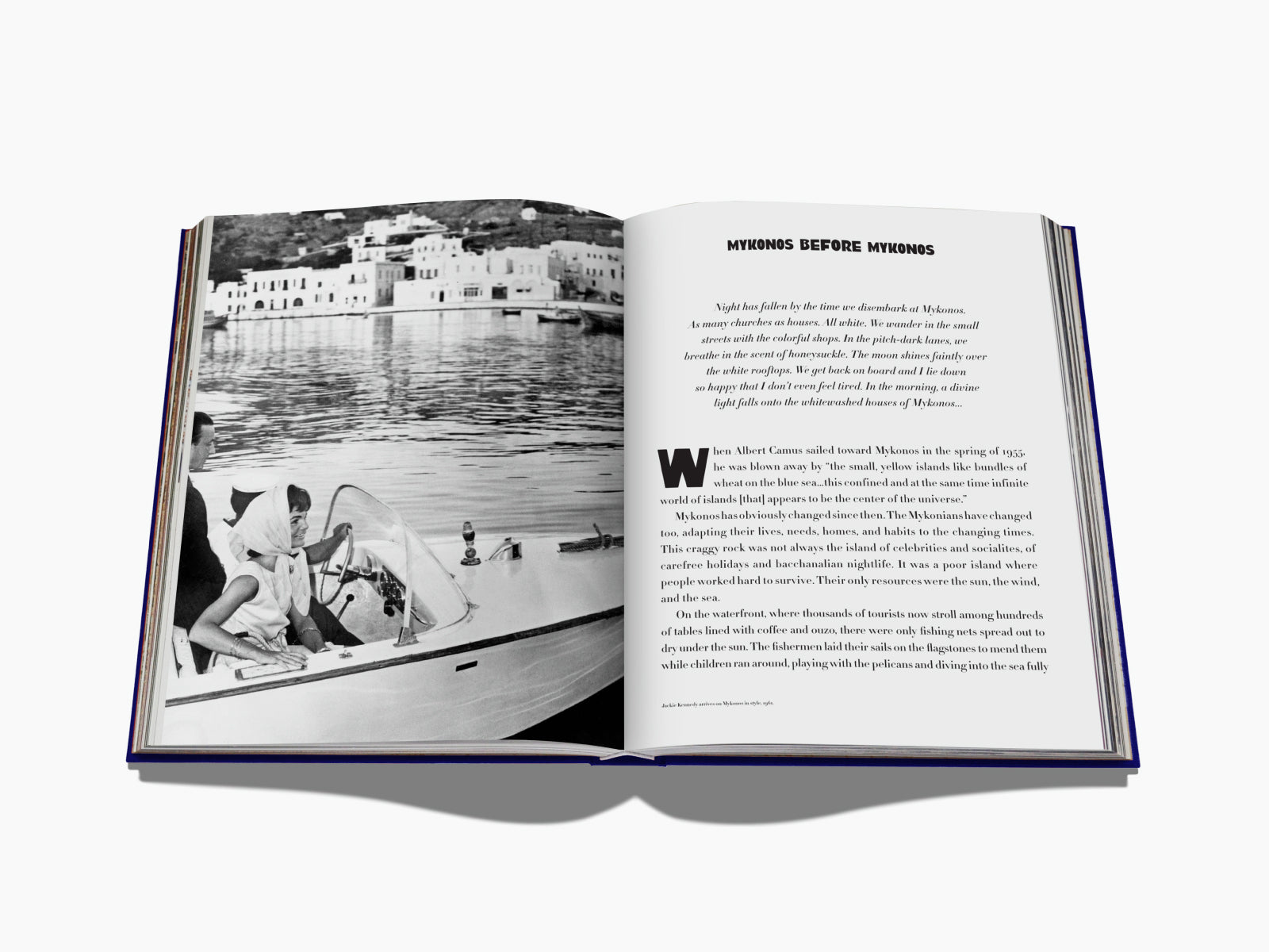 Black and white harbor scene from a Mykonos travel book showing whitewashed buildings along the water