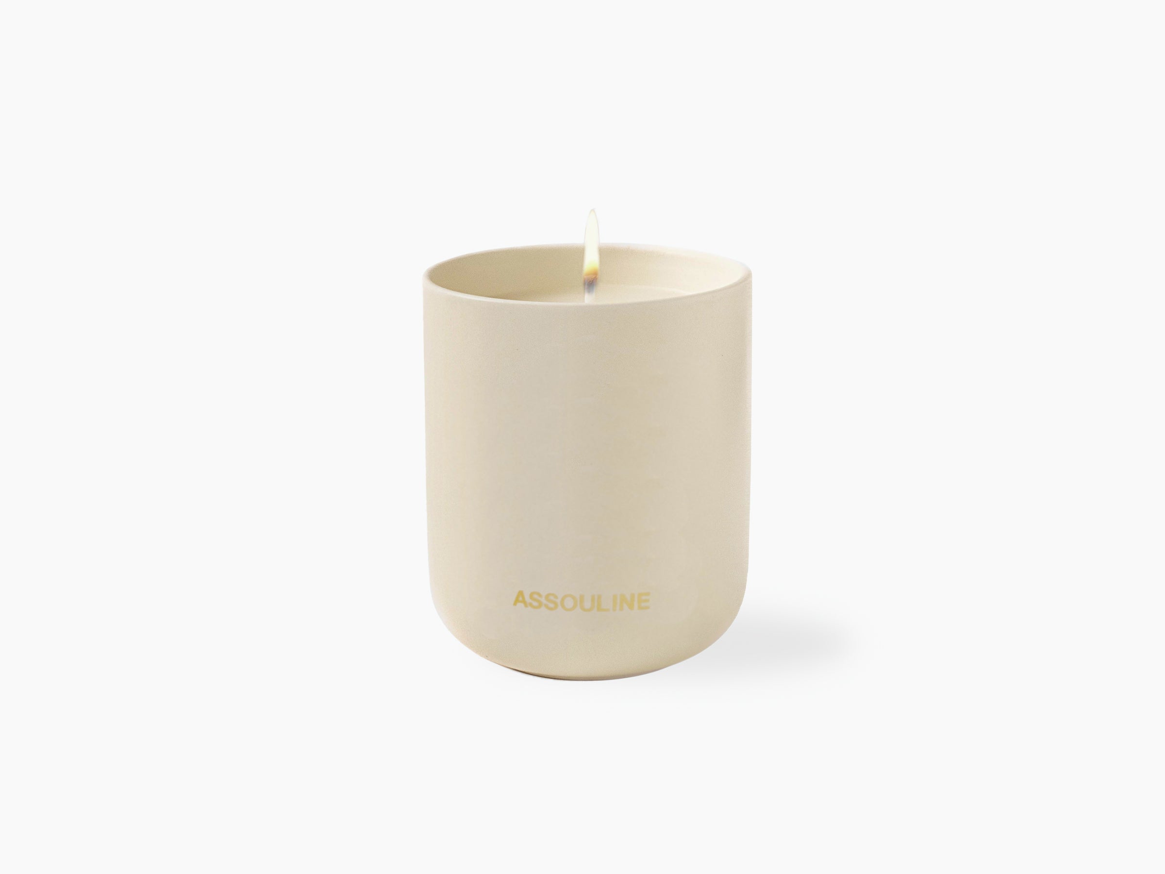 Mykonos Muse Travel From Home scented candle in a beige cylindrical container with Assouline branding.