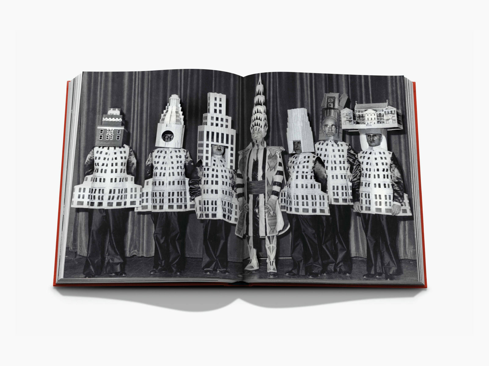 Black and white image from New York by New York of performers wearing cardboard city skyline costumes on a stage