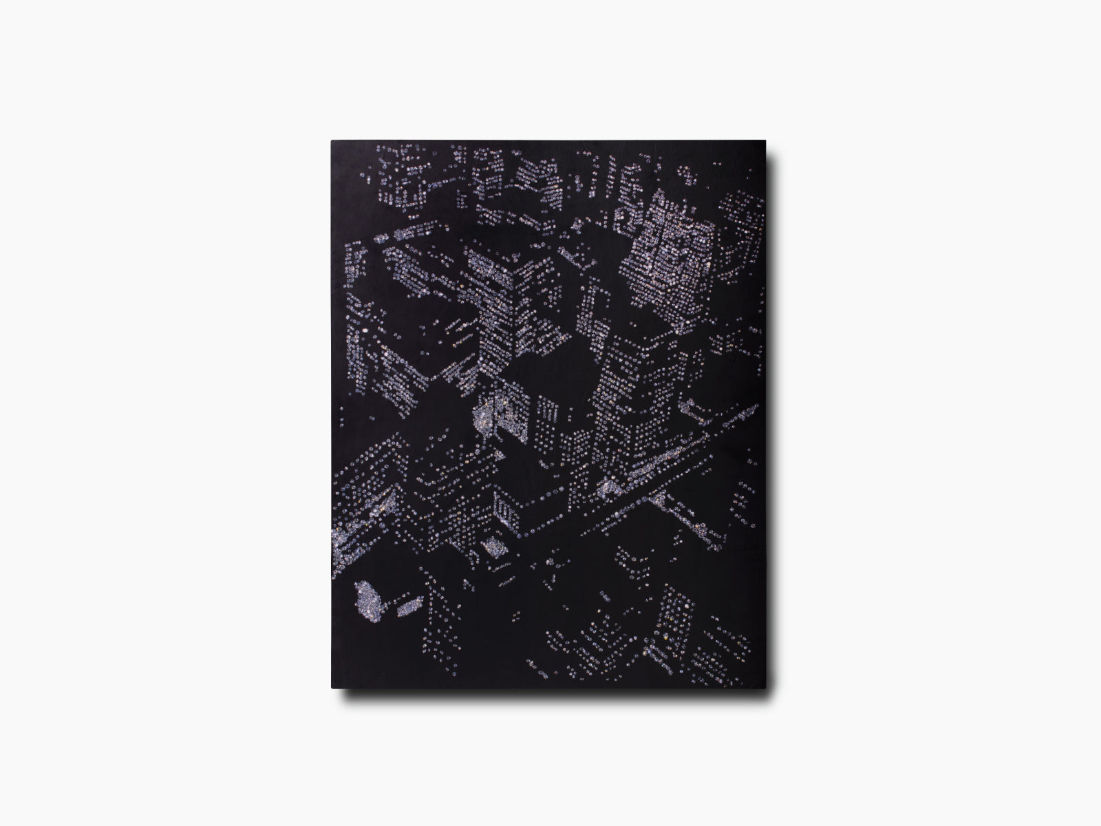 Close up of the New York by New York cover showing a dark surface with a silver dotted pattern.