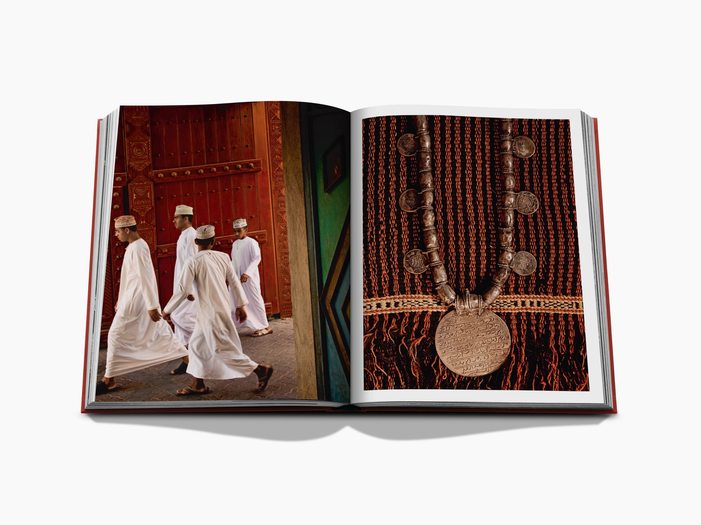 Spread showing men in white robes walking by a red ornate doorway on the left and a beaded coin pendant on patterned fabric on the right.