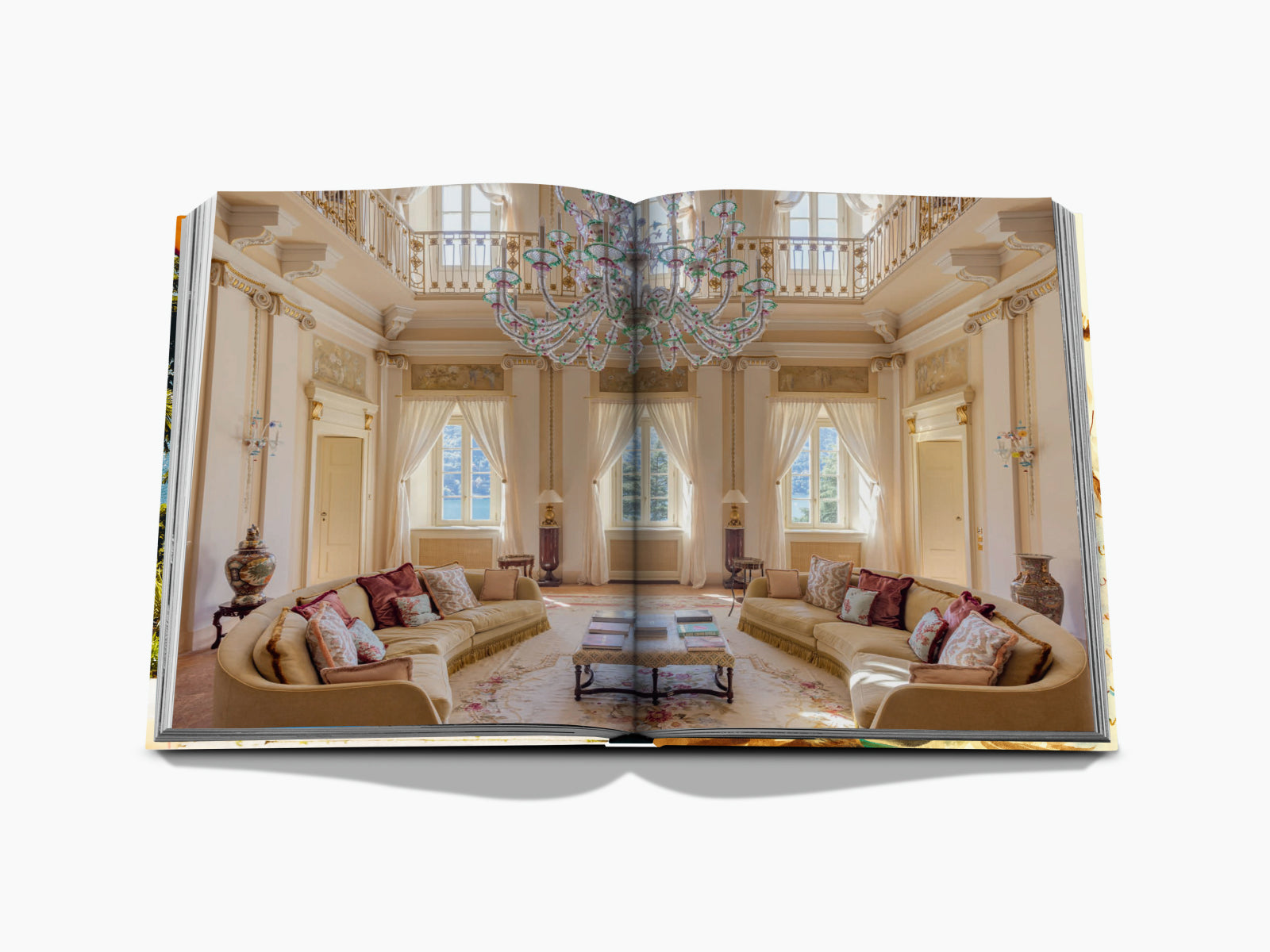 Opulent salon with cream curved sofas and a colorful glass chandelier in a grand Passalacqua interior.