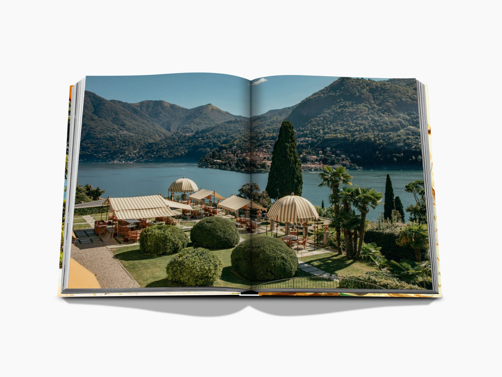 Terraced lakeside garden at Passalacqua with striped canopies and seating overlooking Lake Como.