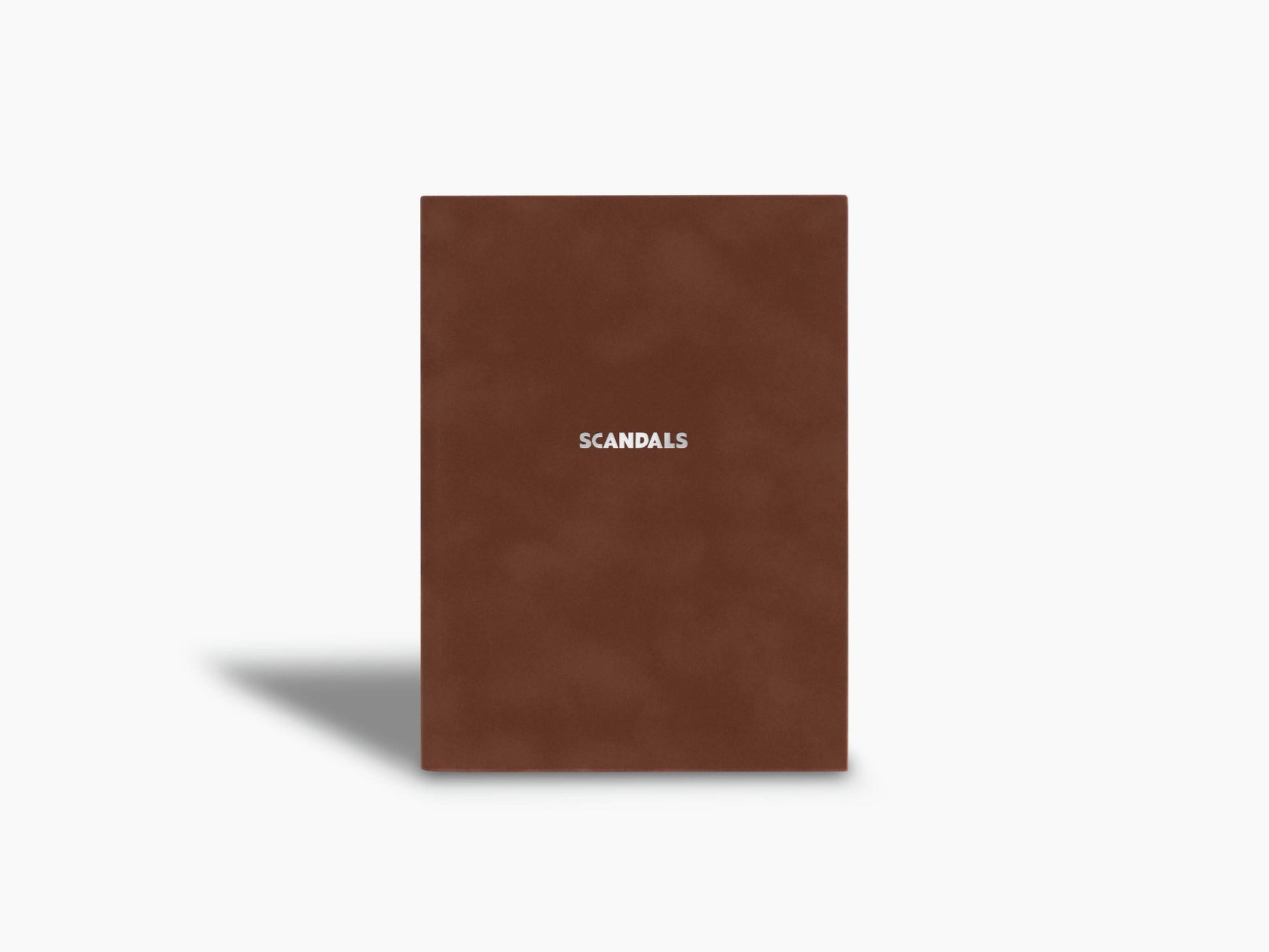 Scandals notebook with brown cover standing upright and minimalist design