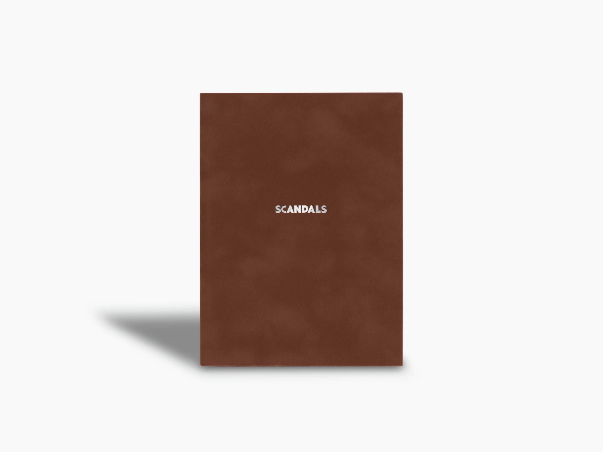 Scandals notebook with brown cover standing upright and minimalist design