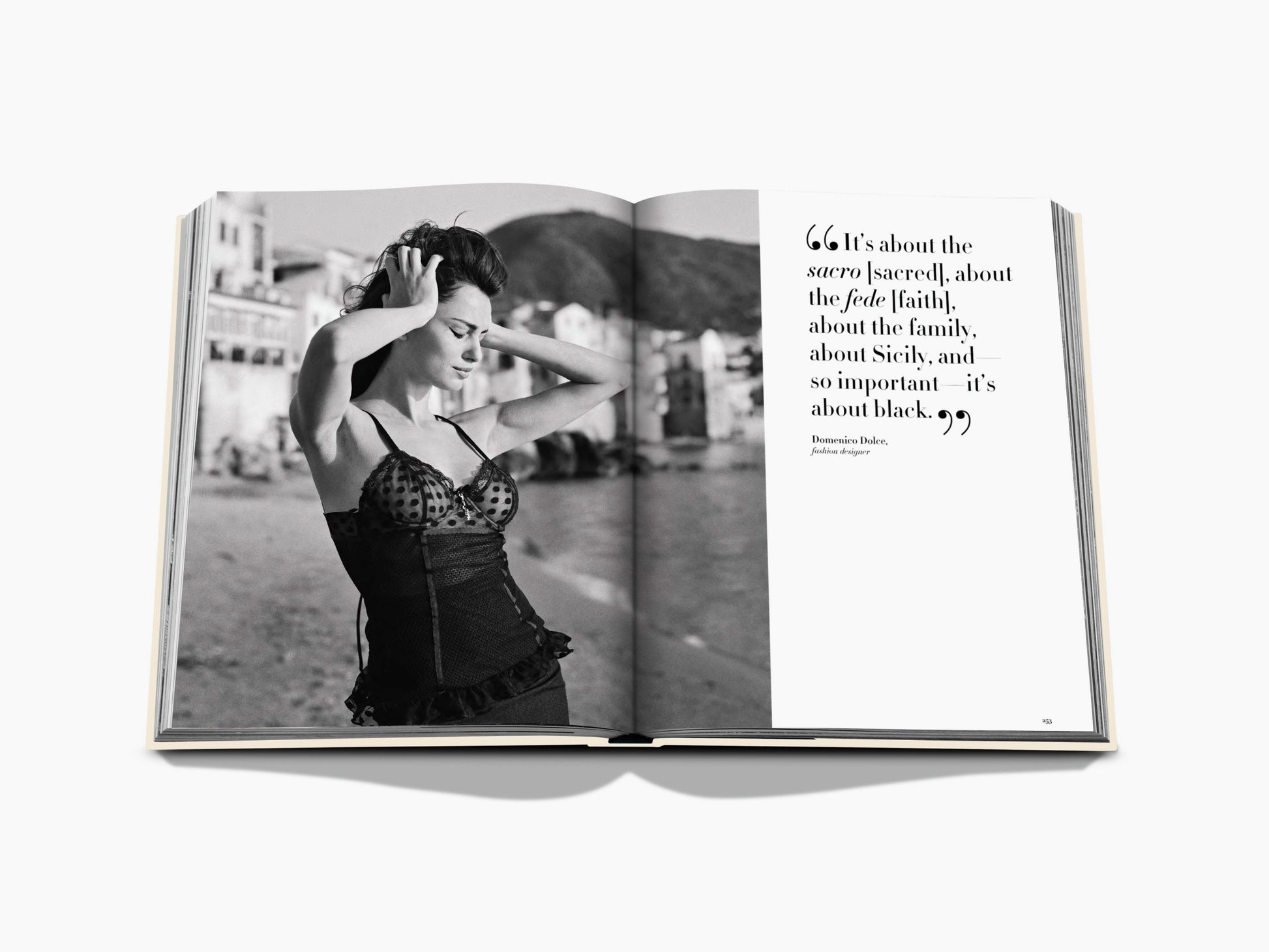 Black and white fashion portrait of a woman in a lace corset beside a seaside street