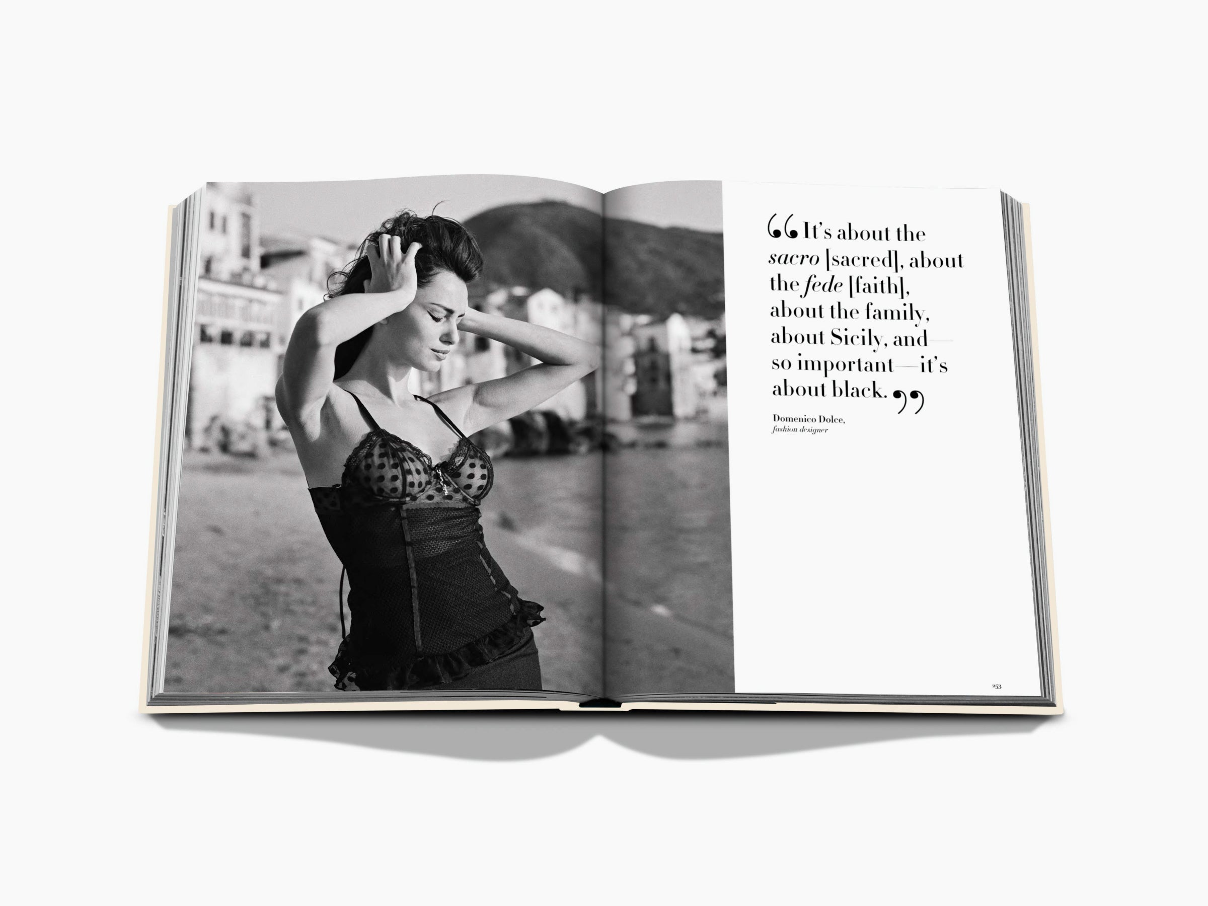 Black and white fashion portrait of a woman in a lace corset beside a seaside street