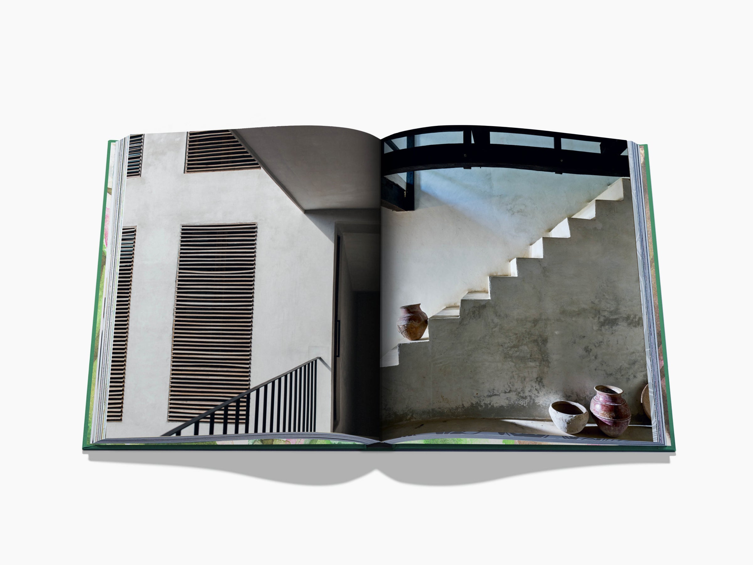 Open book spread showing a minimalist white building with stairs on the left and clay pots on the right page.