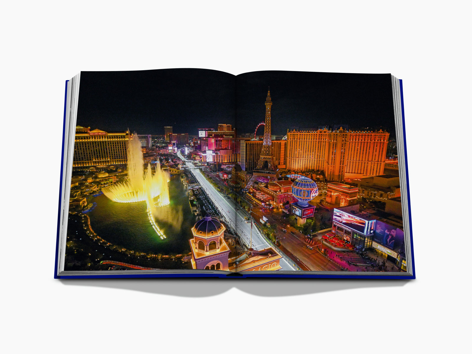 Aerial night view of the Las Vegas Strip with illuminated hotels and the Eiffel Tower replica.