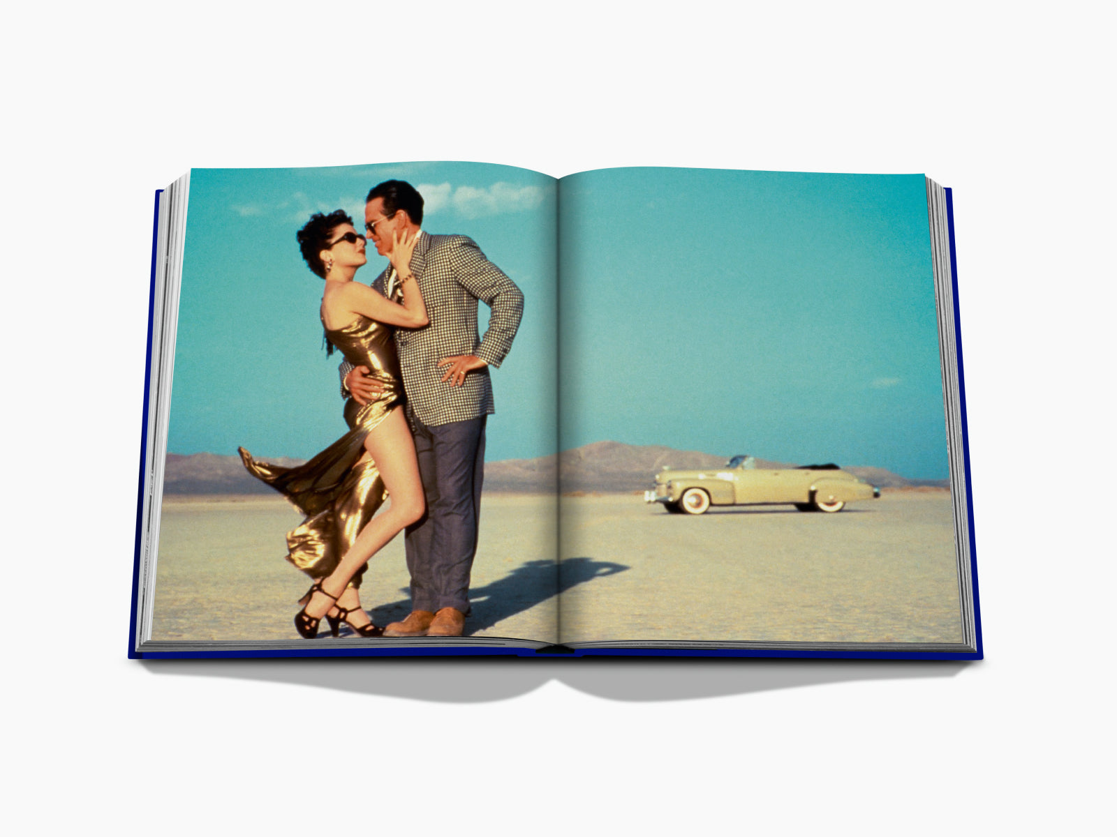 Desert fashion spread featuring a couple embracing with a vintage car in the background.