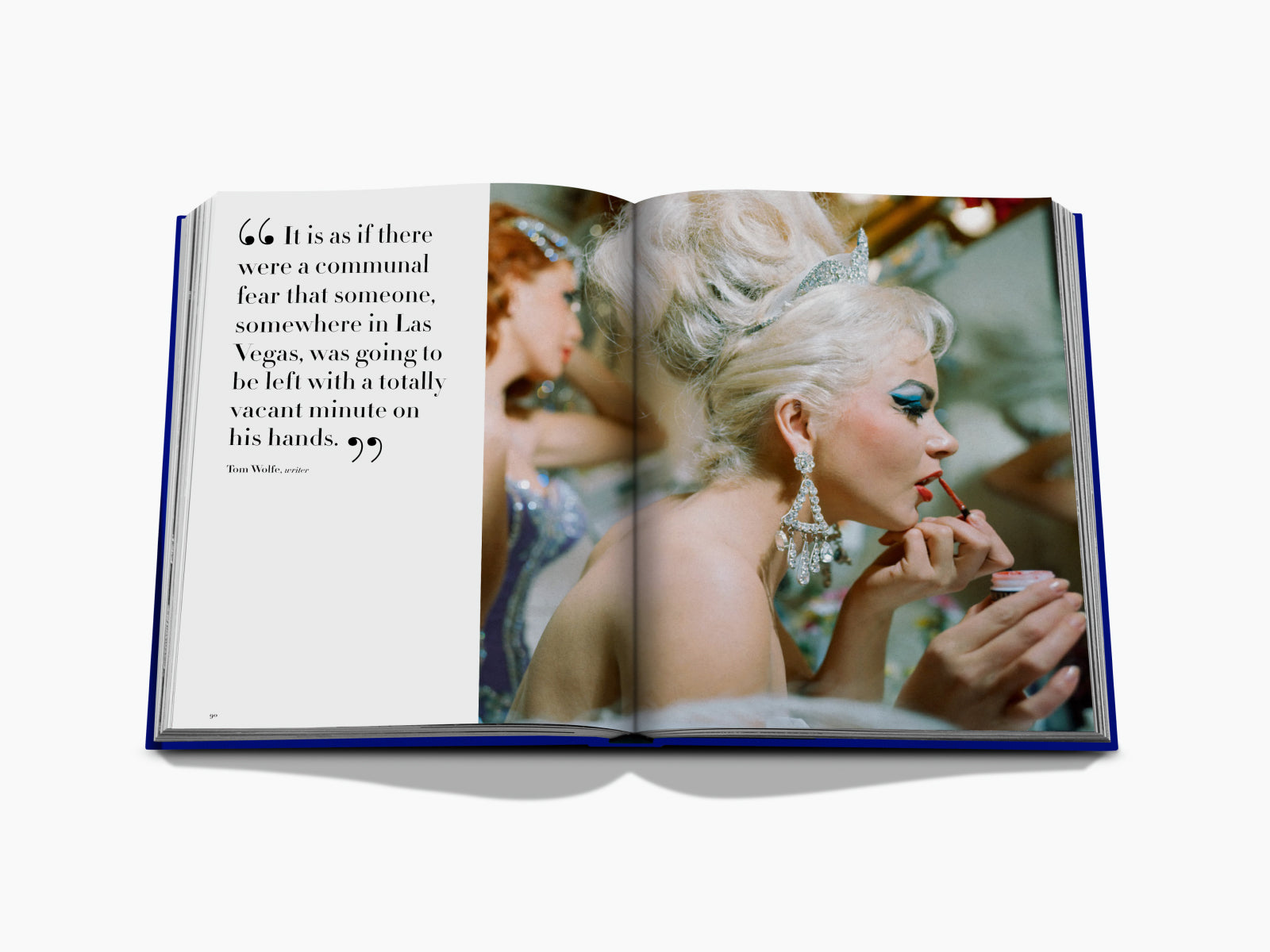 Open book spread with a glamorous woman applying lipstick on the right page and a quote on the left page.