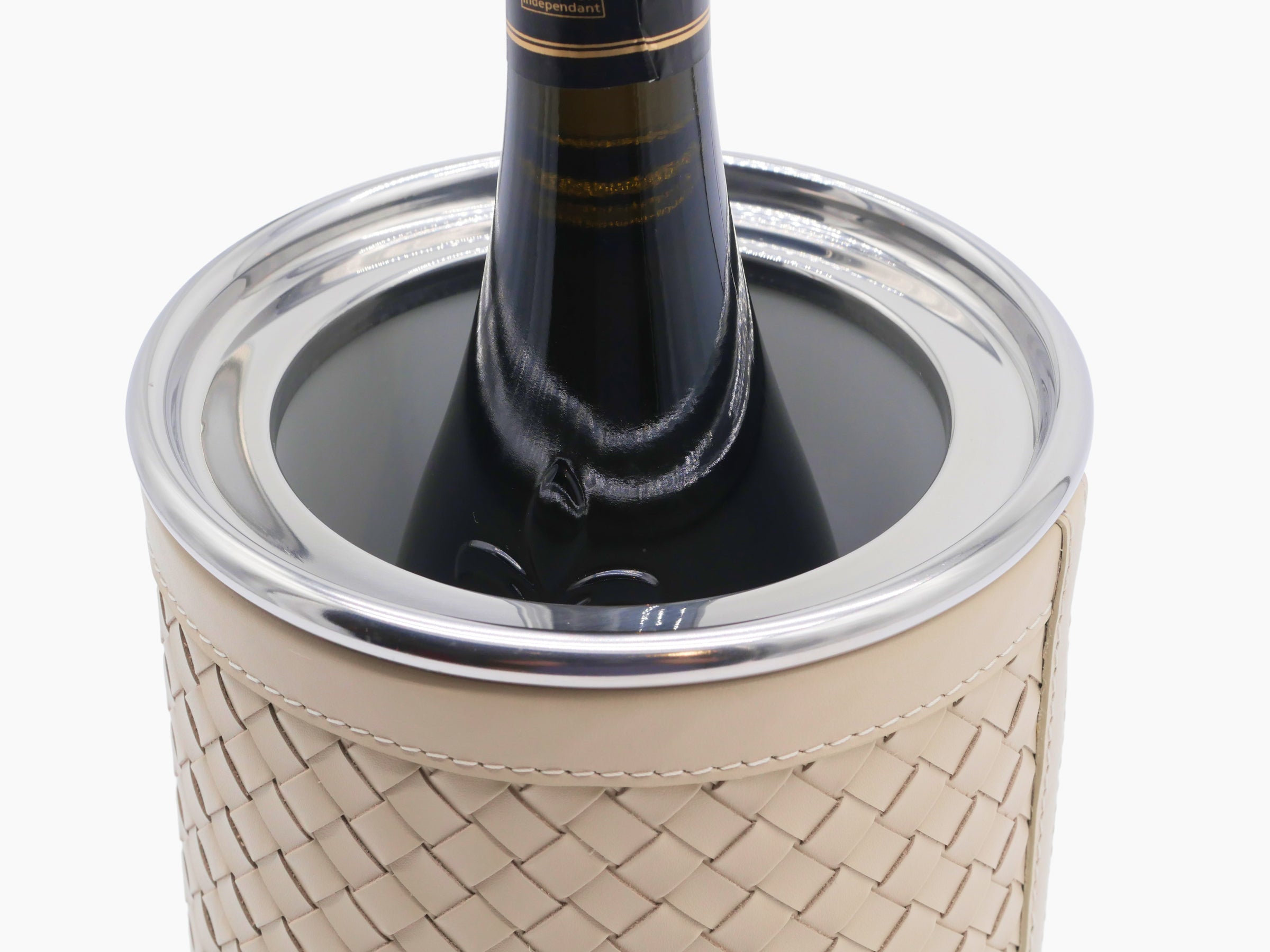 Menfi bottle cooler with ivory handwoven leather wrap and polished stainless steel rim holding a wine bottle.