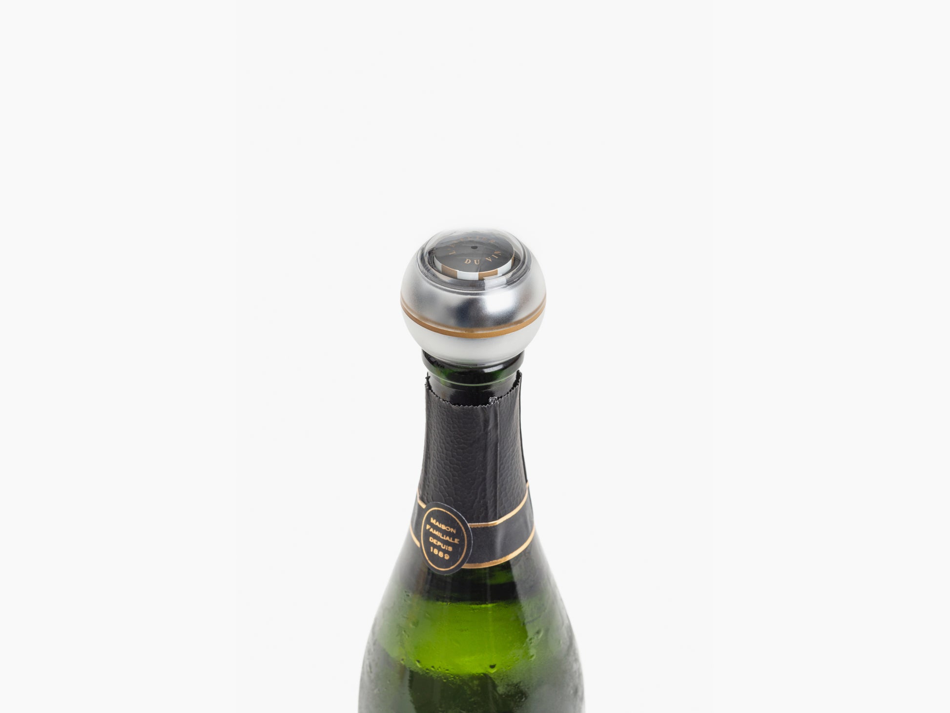 Shiny chrome Bubble Indicator perched on a champagne bottle neck.