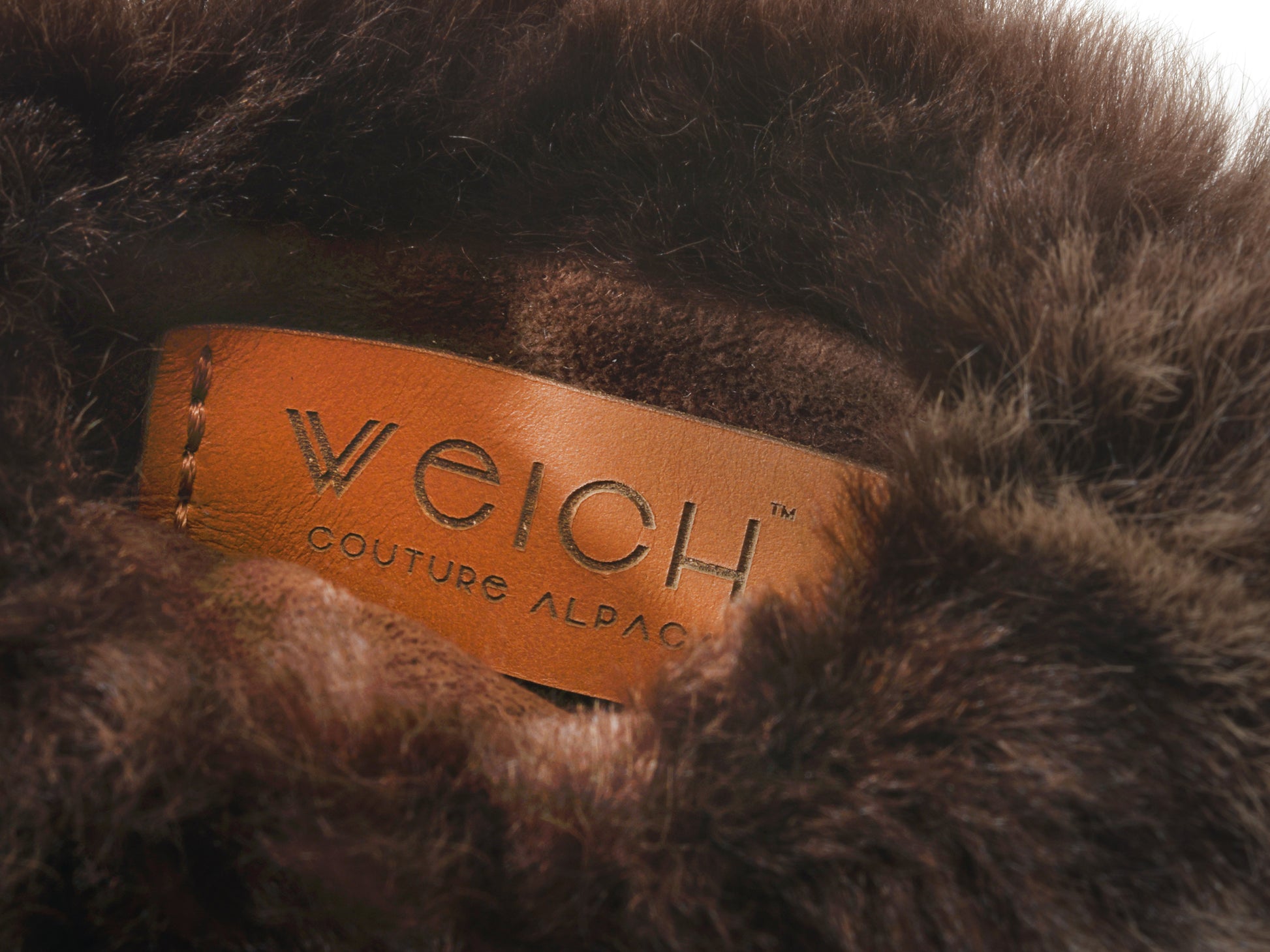 Close up of a brown leather label inside fluffy alpaca fur