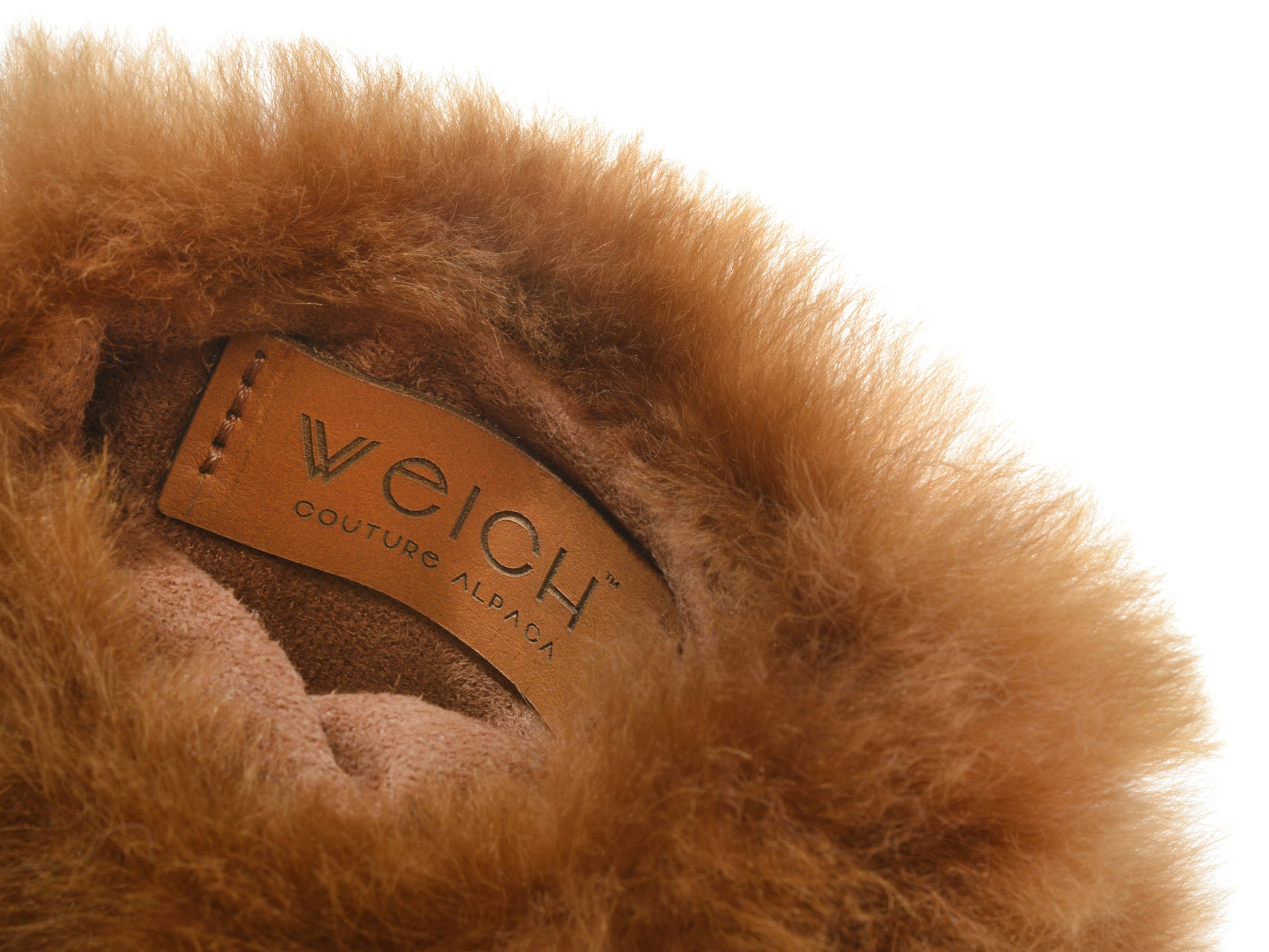 Inside edge of a brown alpaca fur cover showing a Welch Couture Alpaca leather tag.