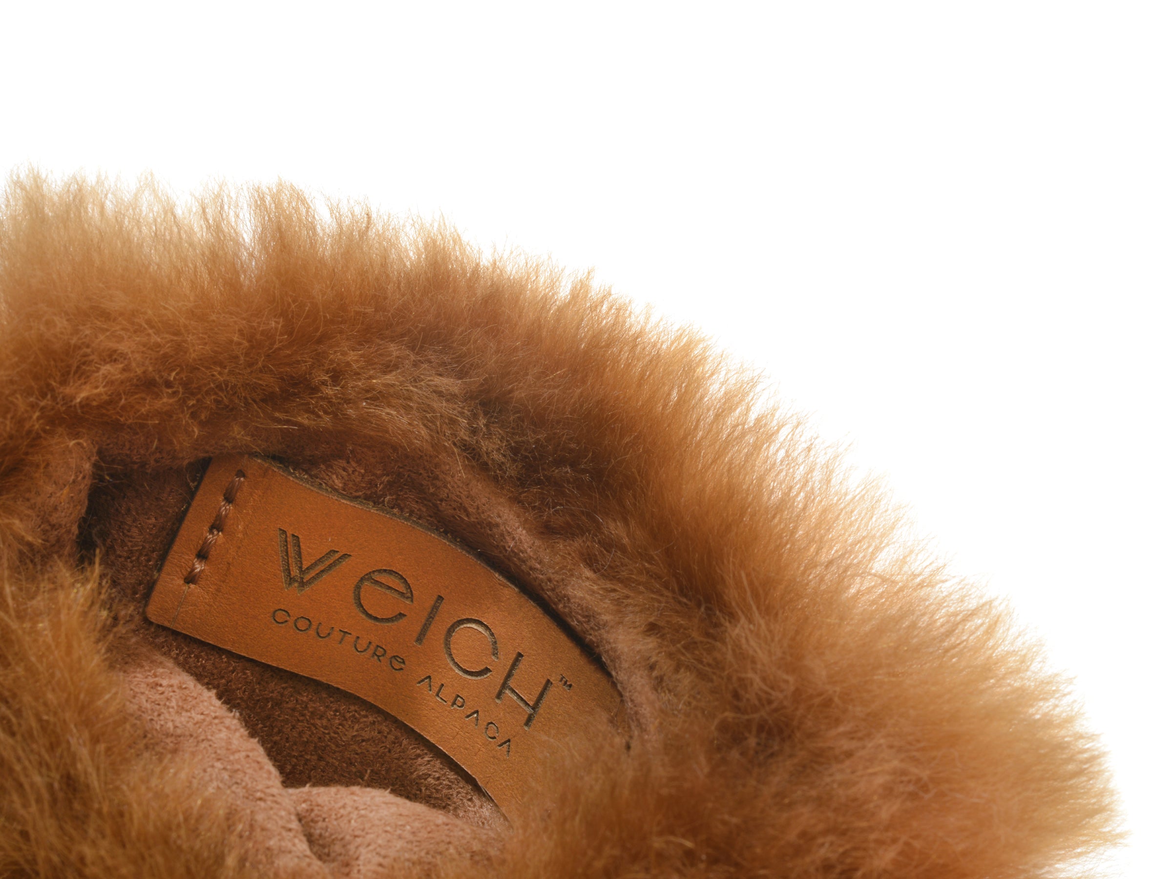 Close-up of CALMO 0.6L hot water bottle wrapped in soft alpaca fur with a tan leather WECH tag