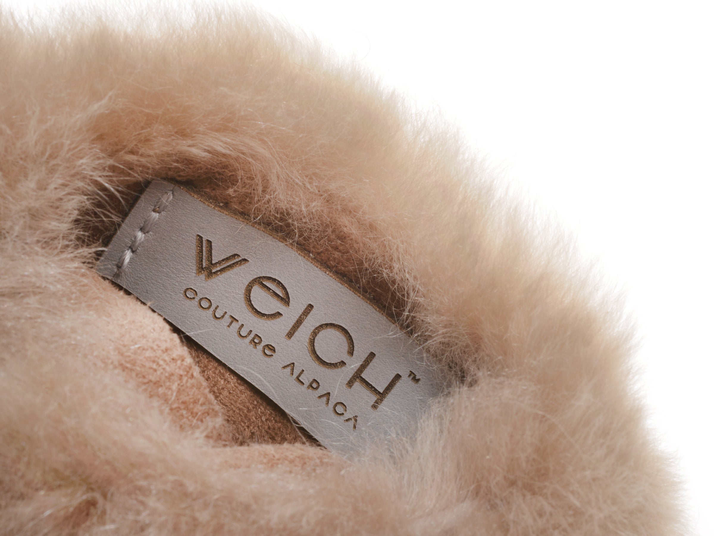 Close-up of gray WECH couture alpaca tag nestled in the warm fur around CALMO