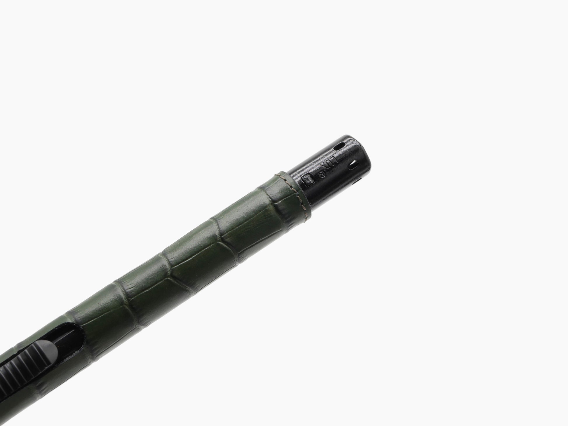 Close-up of the lighter showing green leather wrap and black metal nozzle