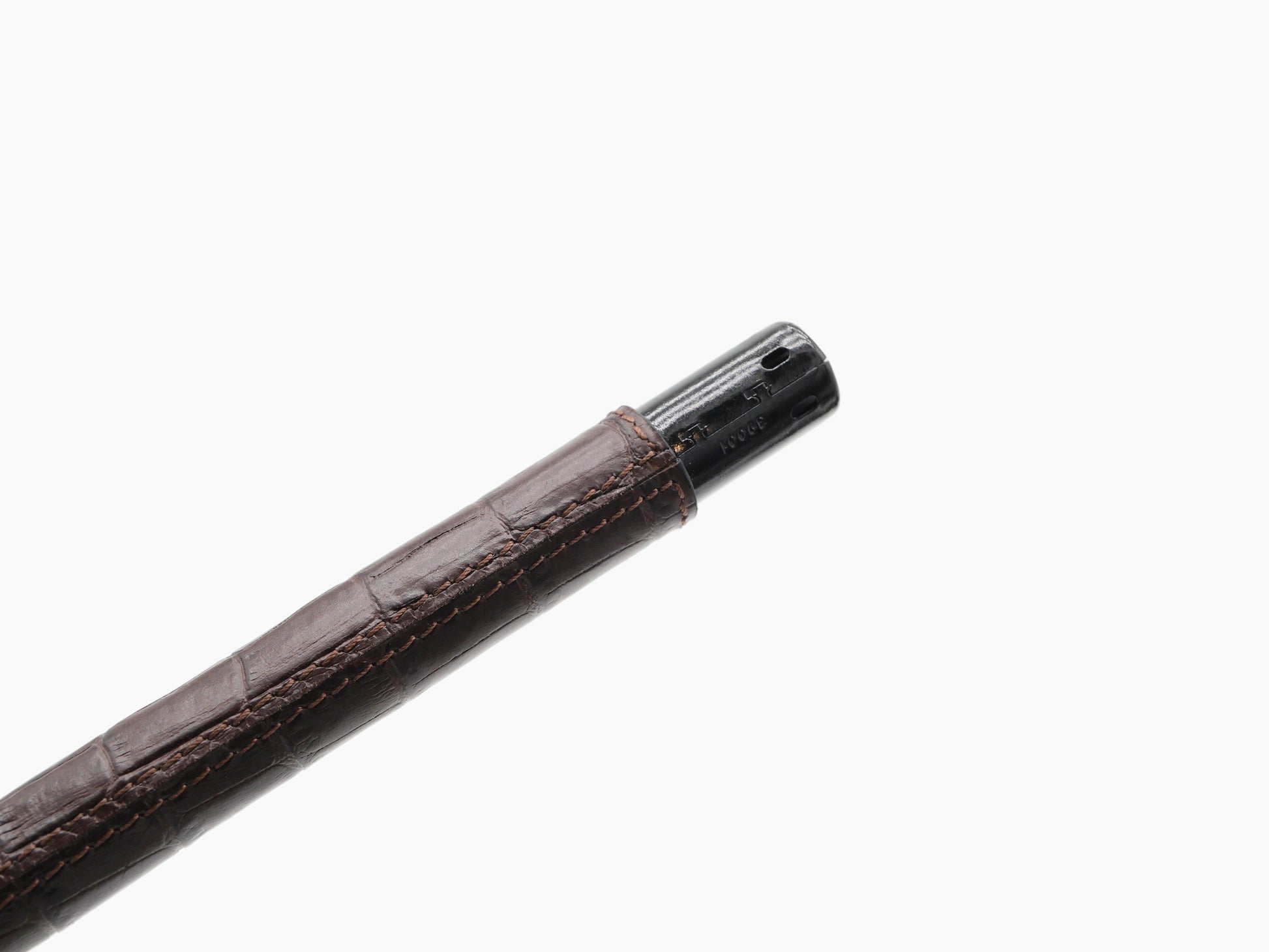 Brown leather wrapped candle lighter shaft with visible stitching and black metal tip.