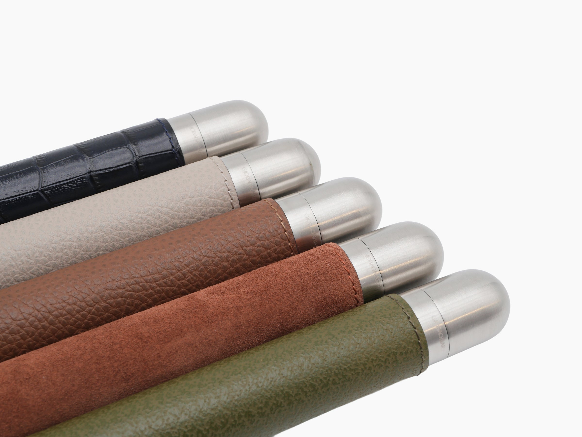 Six satin metal cigar holders with leather wraps arranged diagonally.