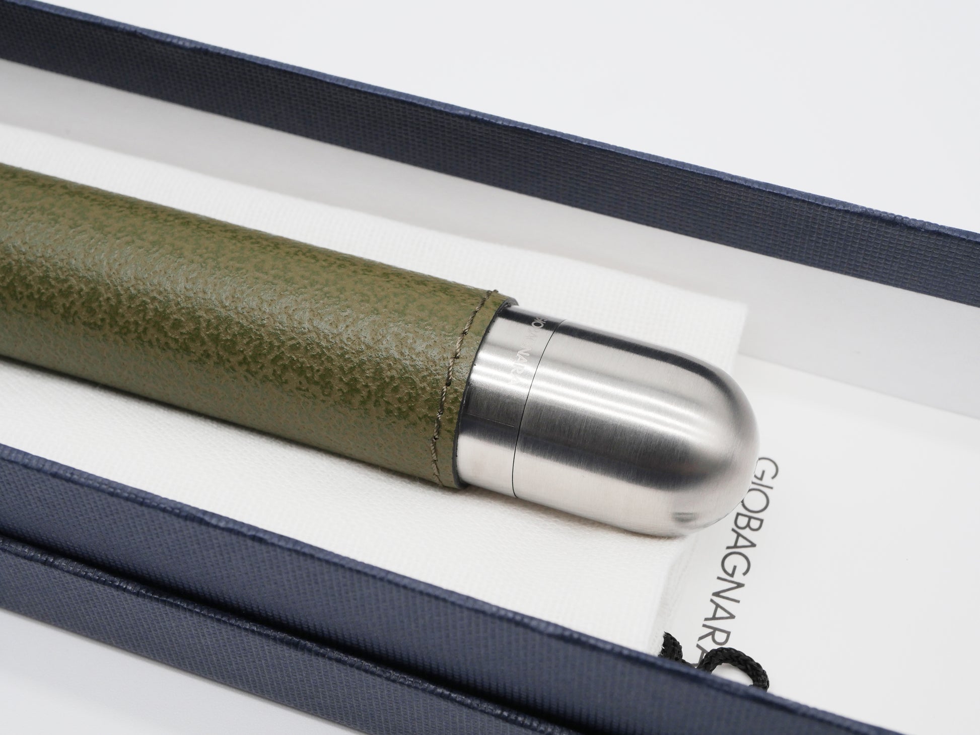 Stainless steel cigar holder with a satin finish partially wrapped in green leather placed in a navy presentation case.