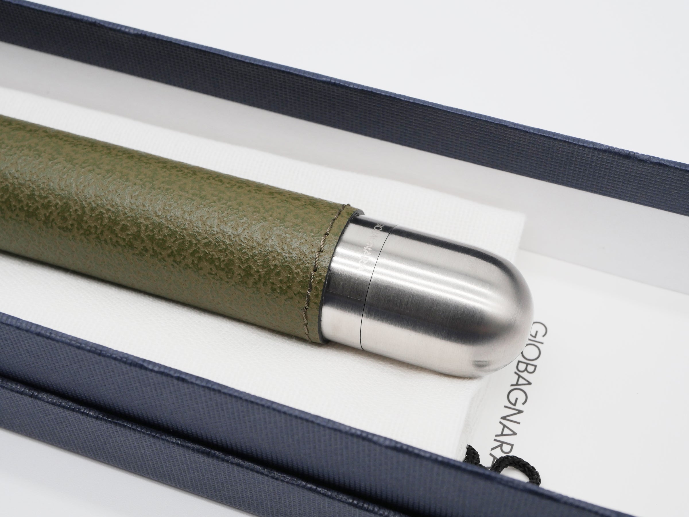 Stainless steel cigar holder with a satin finish partially wrapped in green leather placed in a navy presentation case.