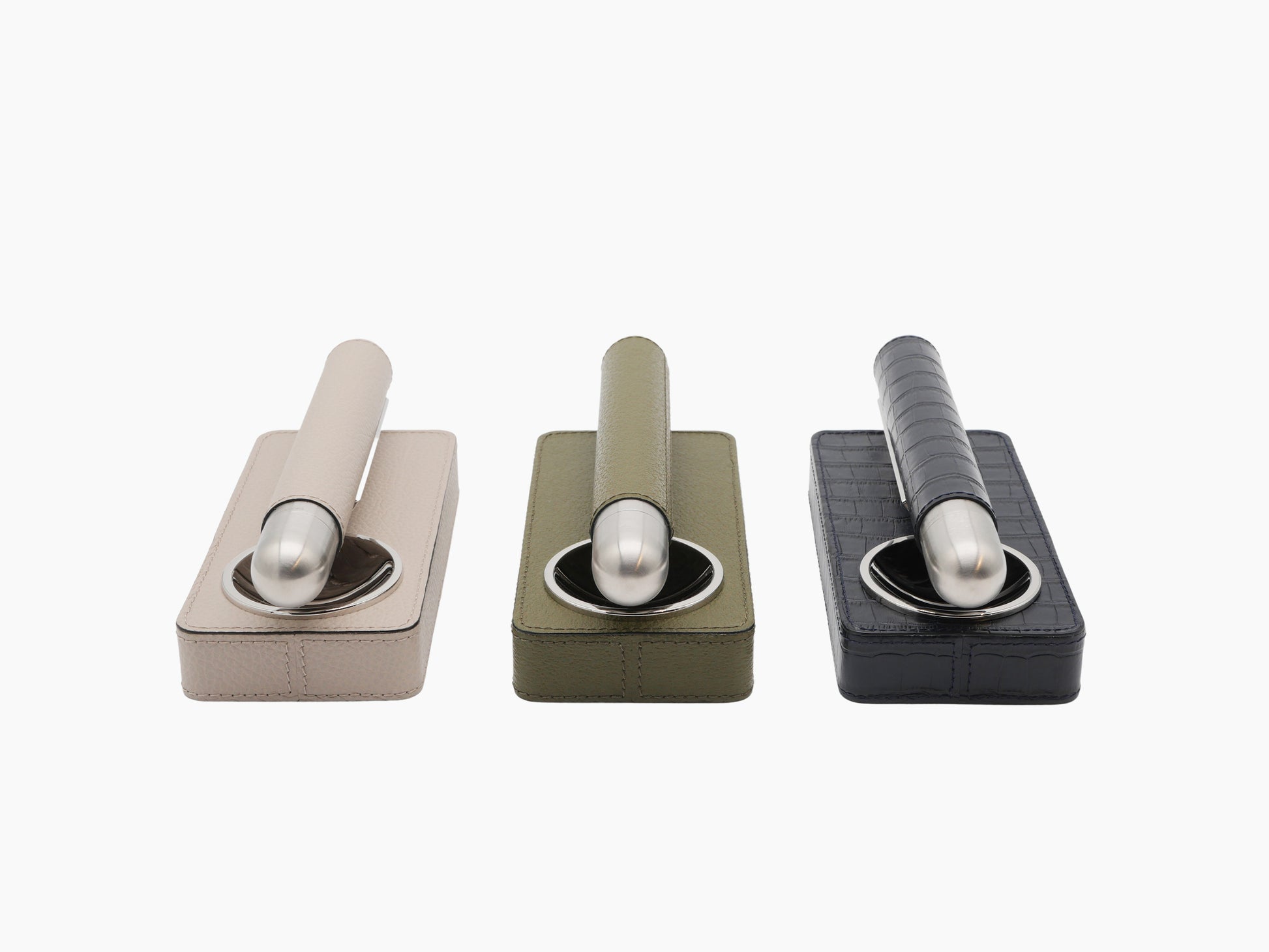 Three color variants of Cigar Holder Gift Set in beige olive and navy leather with stainless steel cigar holders displayed in a row.