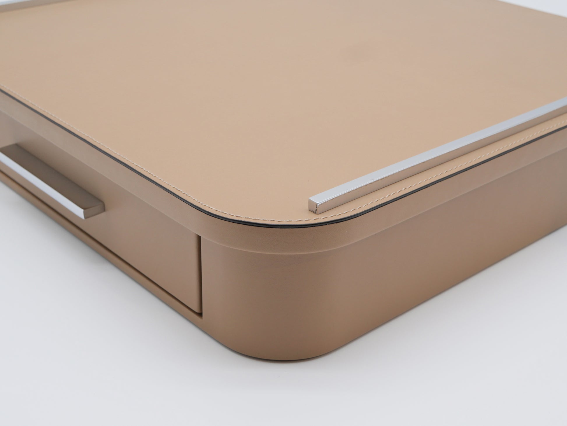 Corner view of Saint–Germain Classic Capsule Drawer in tan leather with a marble top and chrome rail.