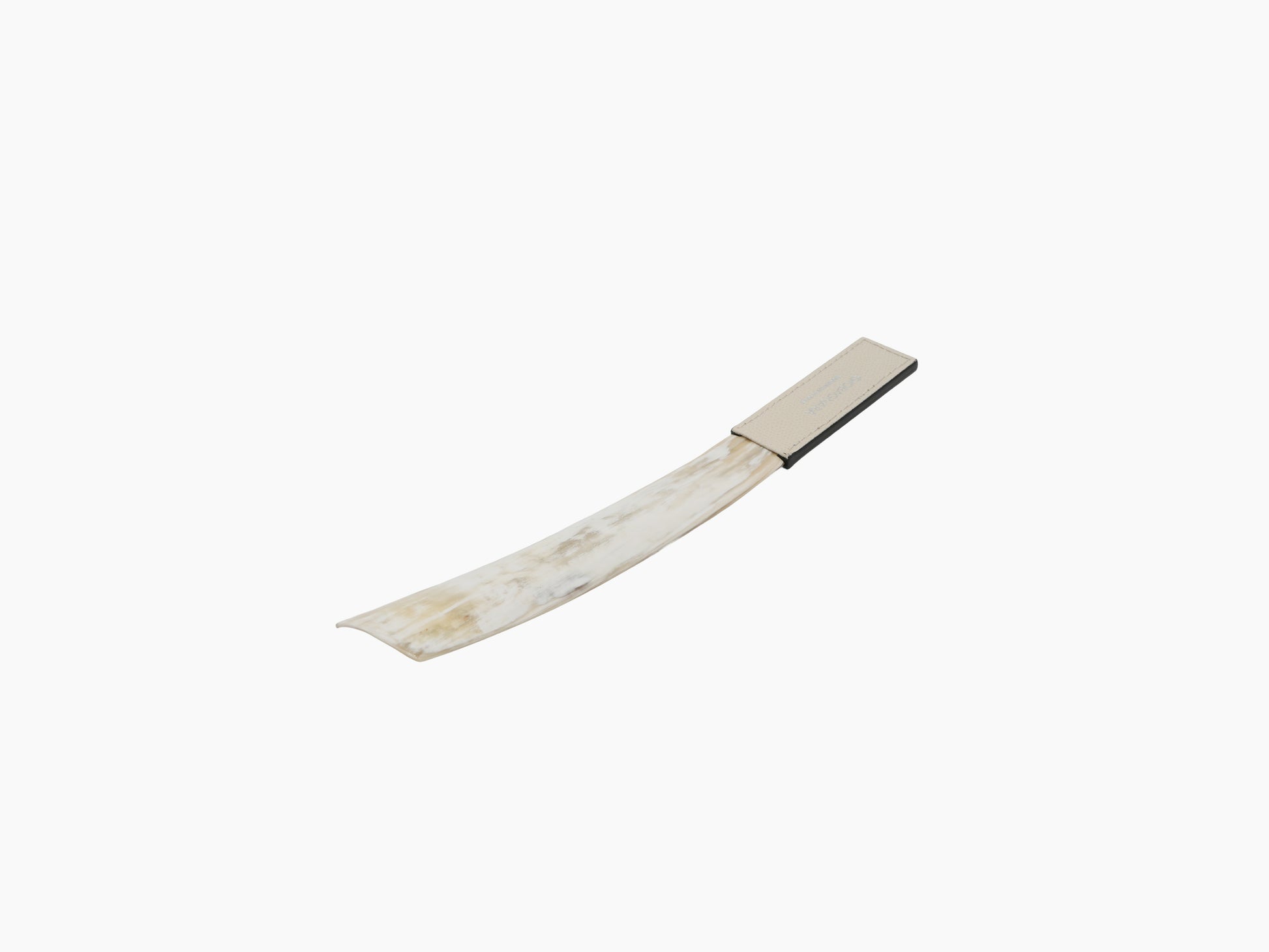 Curved buffalo horn shoehorn with pale leather end cap on white background