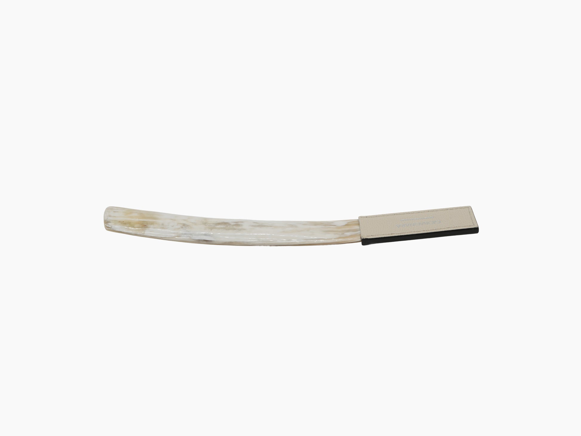Handcrafted buffalo horn shoehorn with tan leather end cap on white background