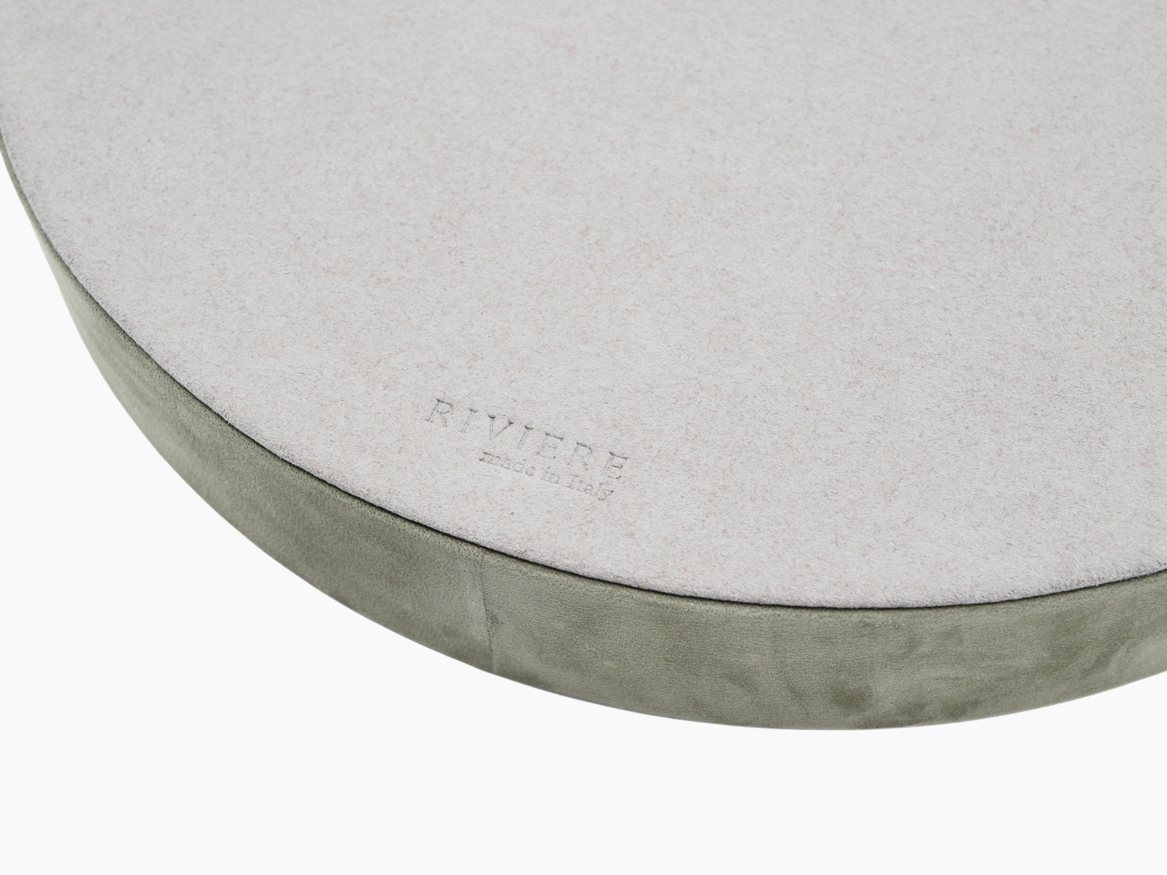 Close-up of Dama Round Valet Tray with a pale top surface and green suede edge, featuring a subtle brand stamp.