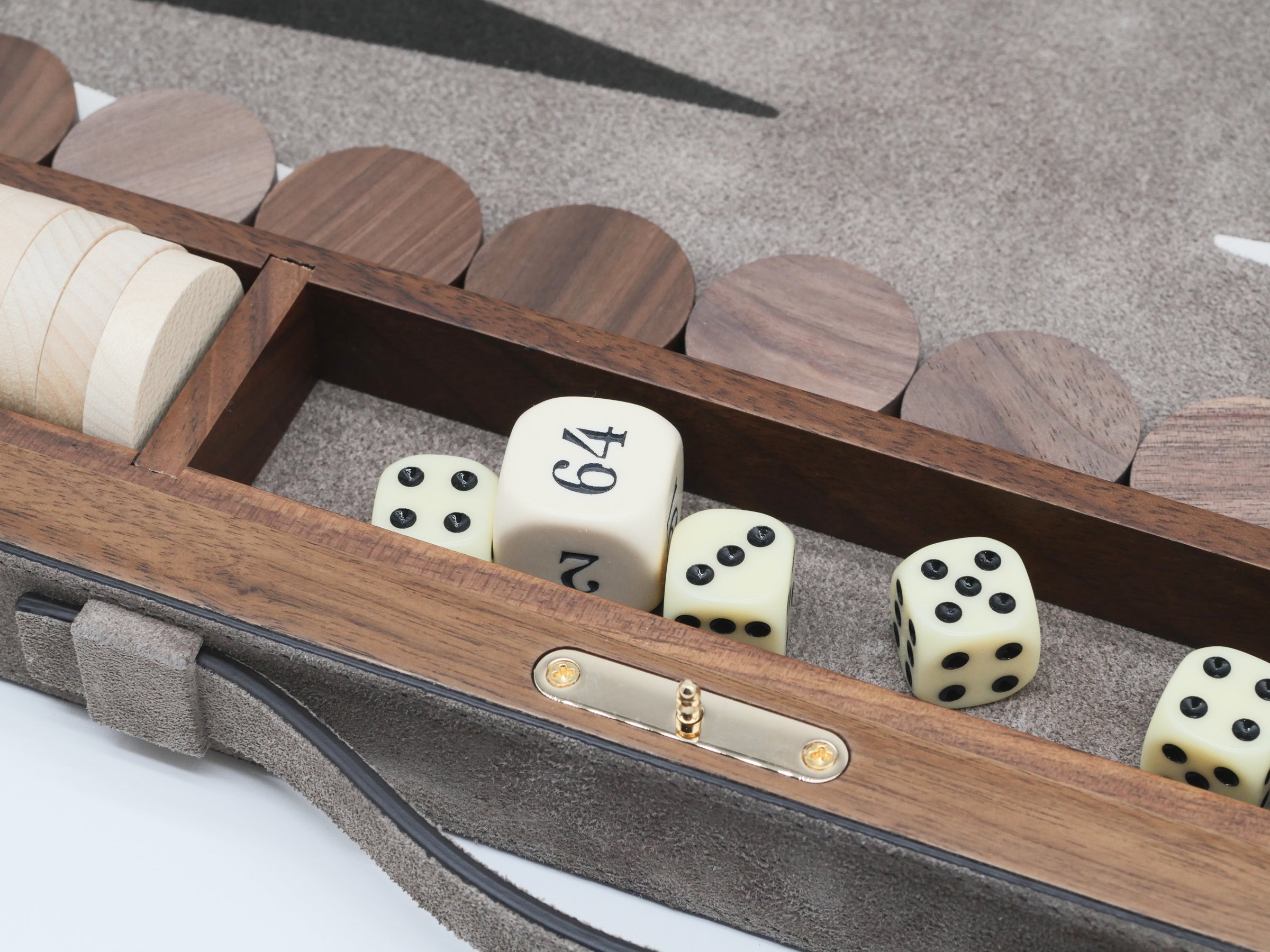 Open Bond backgammon case showing ivory dice and polished boxwood checkers in a suede-lined interior