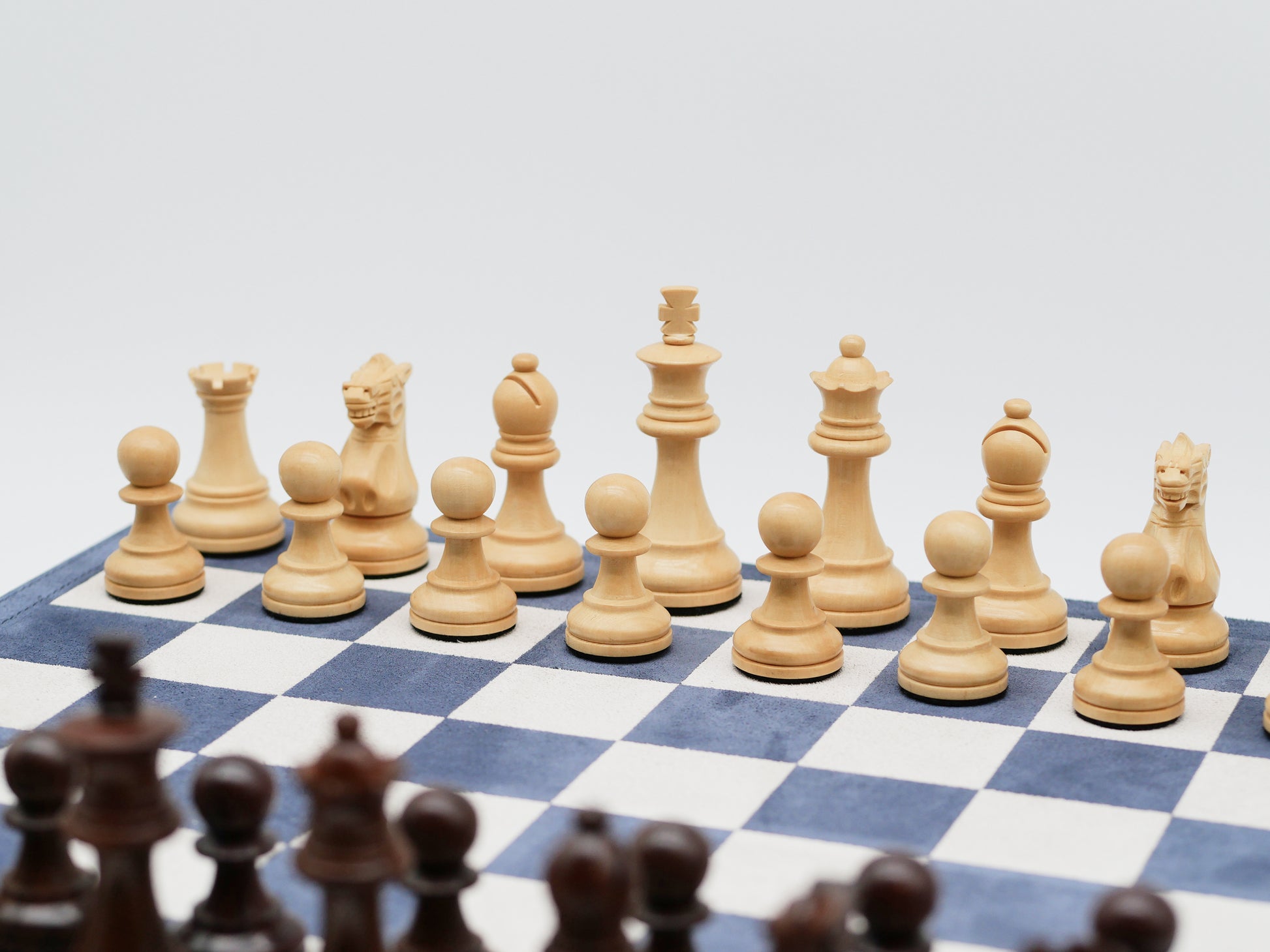 Light wooden chess pieces on a blue and white chessboard from the 3 in 1 set