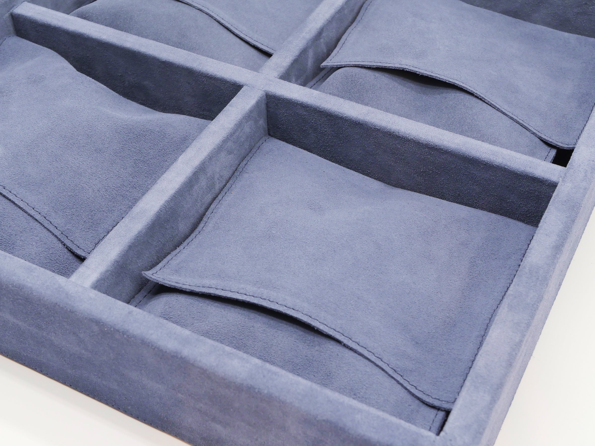 Blue suede interior with divided compartments for chess checkers and domino pieces inside a leather 3 in 1 game case
