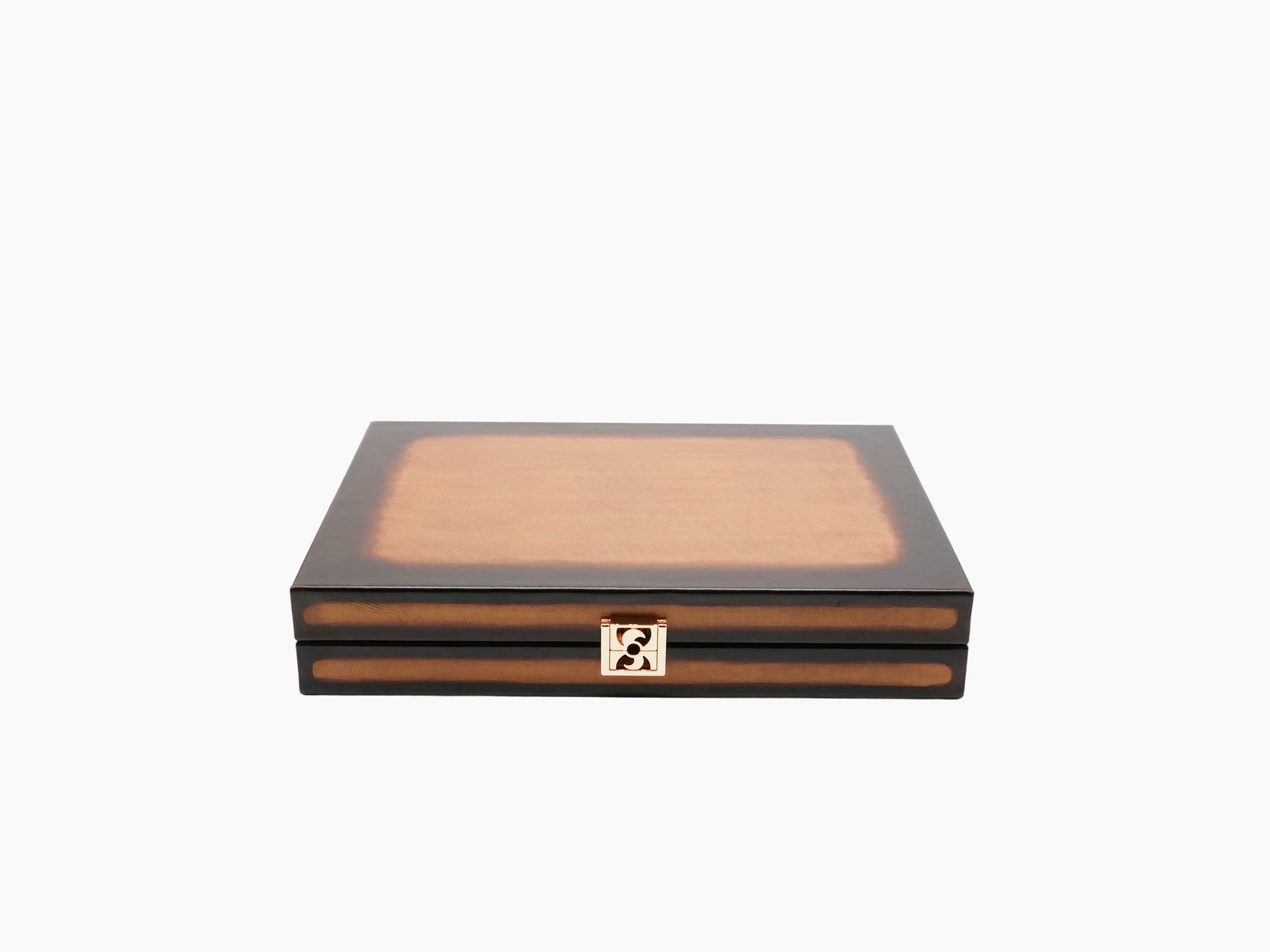 Closed patinable cognac leather backgammon box with a gold clasp against a light background.