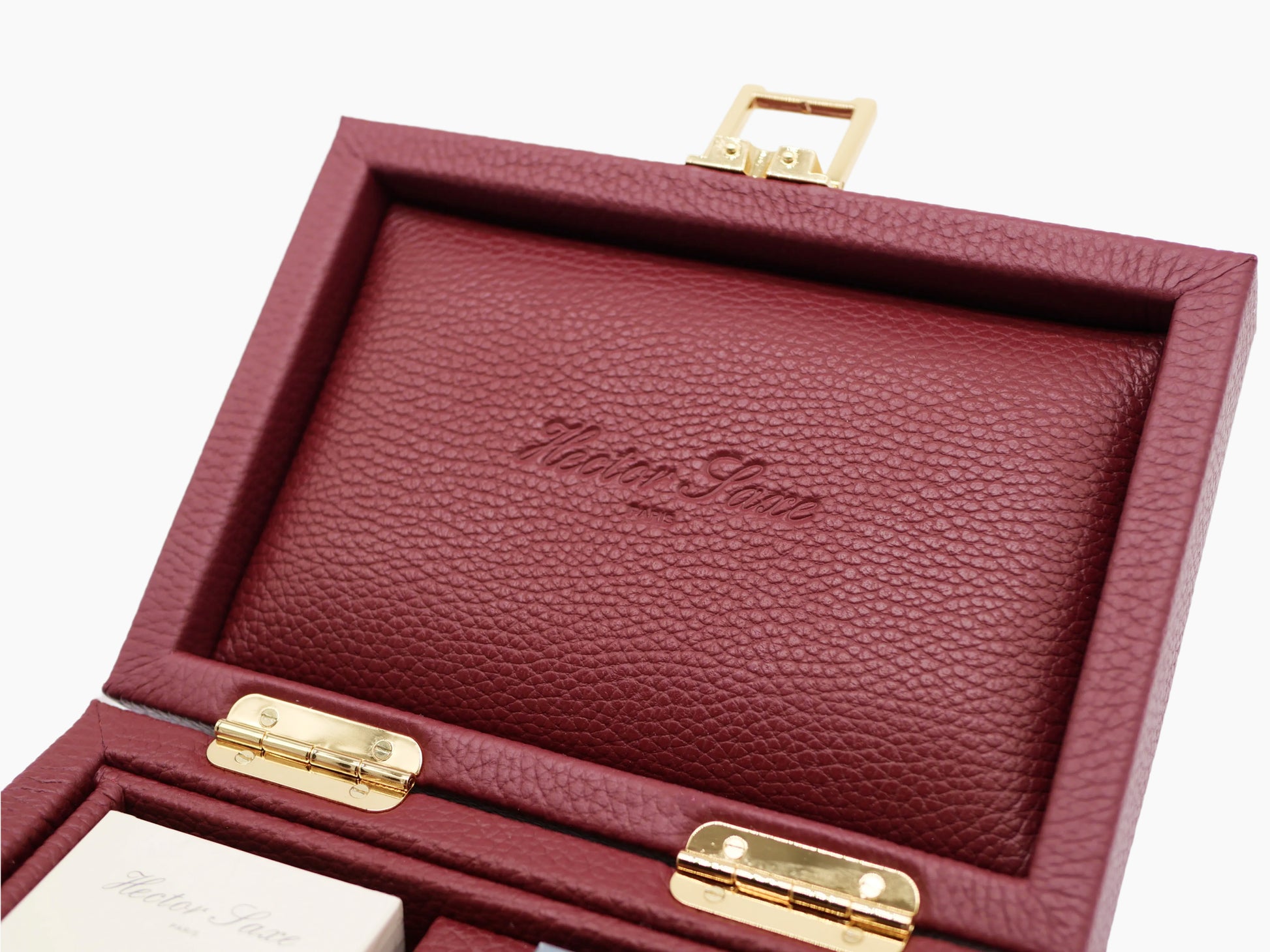 Close up of burgundy buffalo leather card box interior lid with embossed logo and gold hardware.