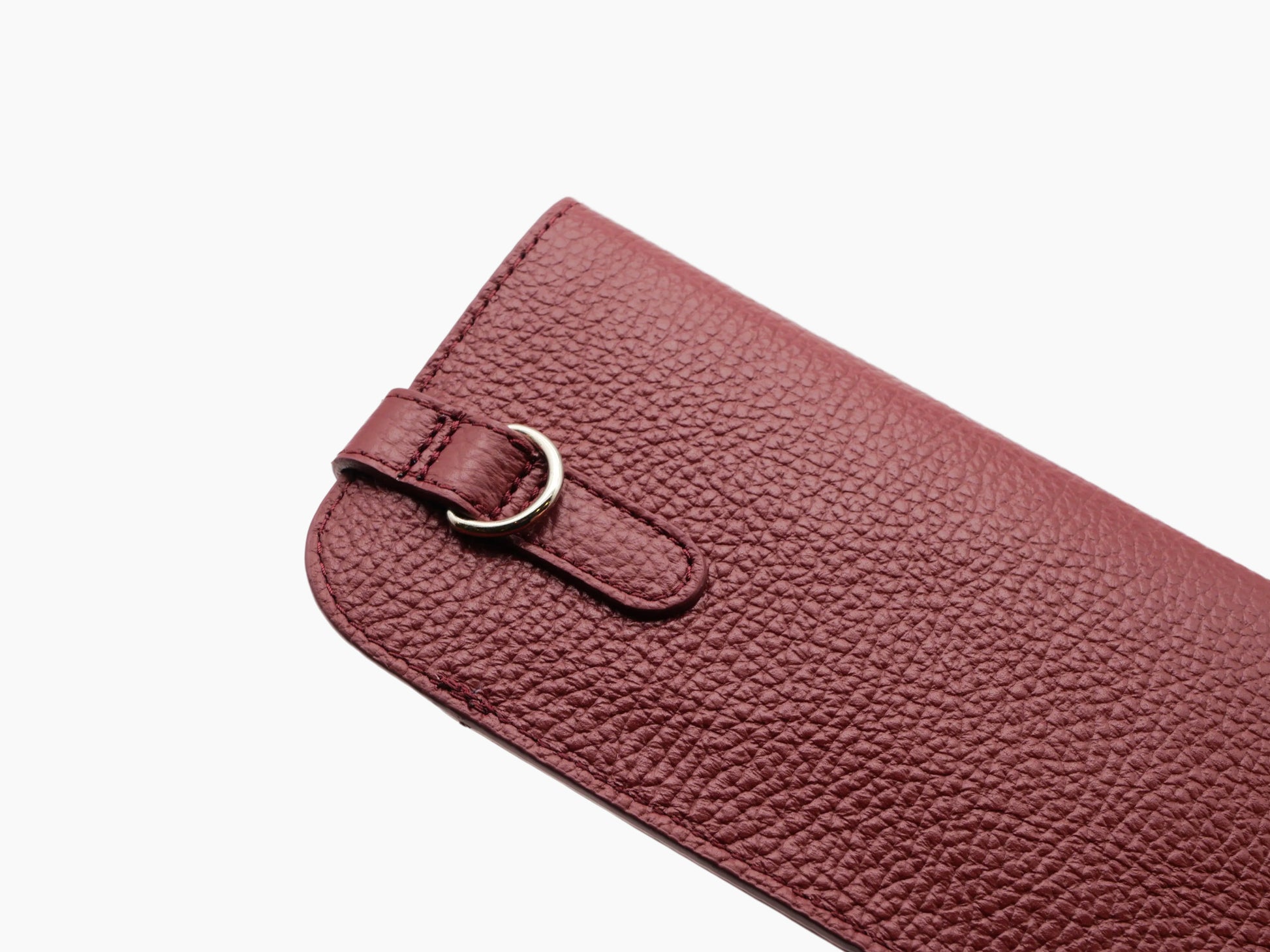 Close-up of textured Buffalo Bordeaux leather glasses case with strap and ring