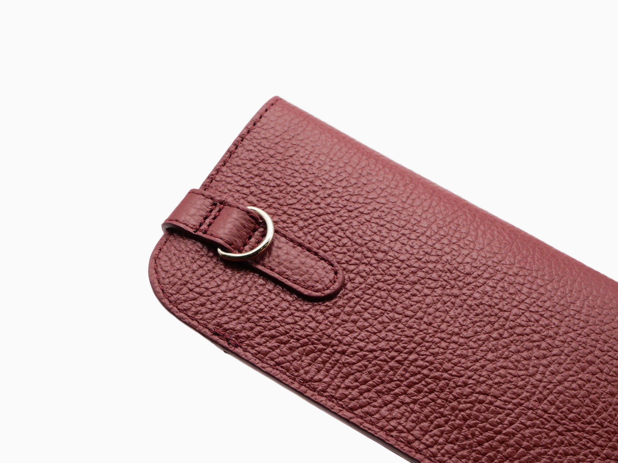 Close-up of textured Buffalo Bordeaux leather glasses case with strap and ring